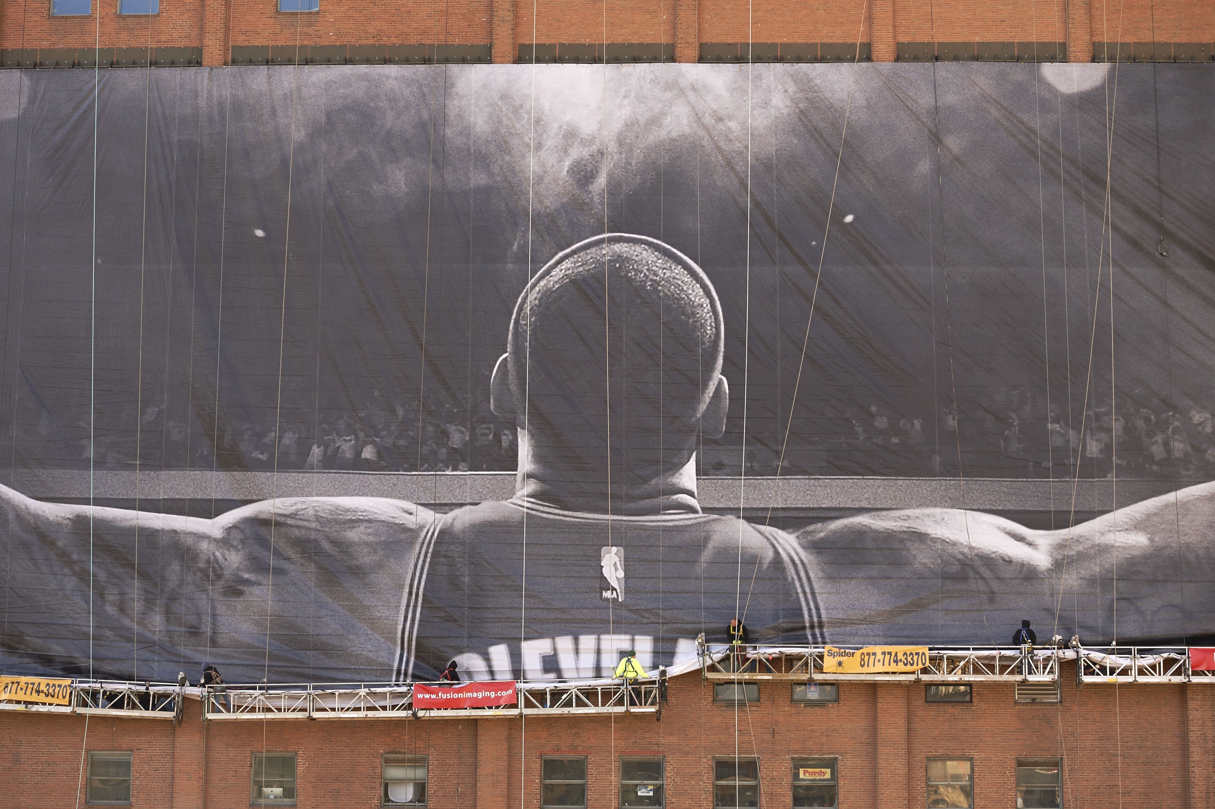 A giant banner of LeBron James is unfurled across a building. 