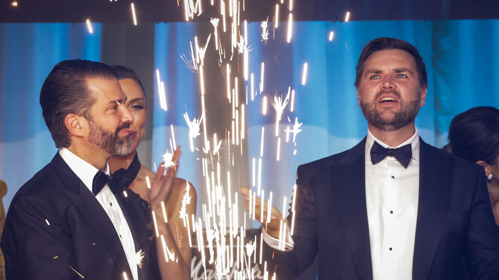 Donald Trump Jr. and Vice President Vance, dressed in tuxedos, with a sparkler in between them.