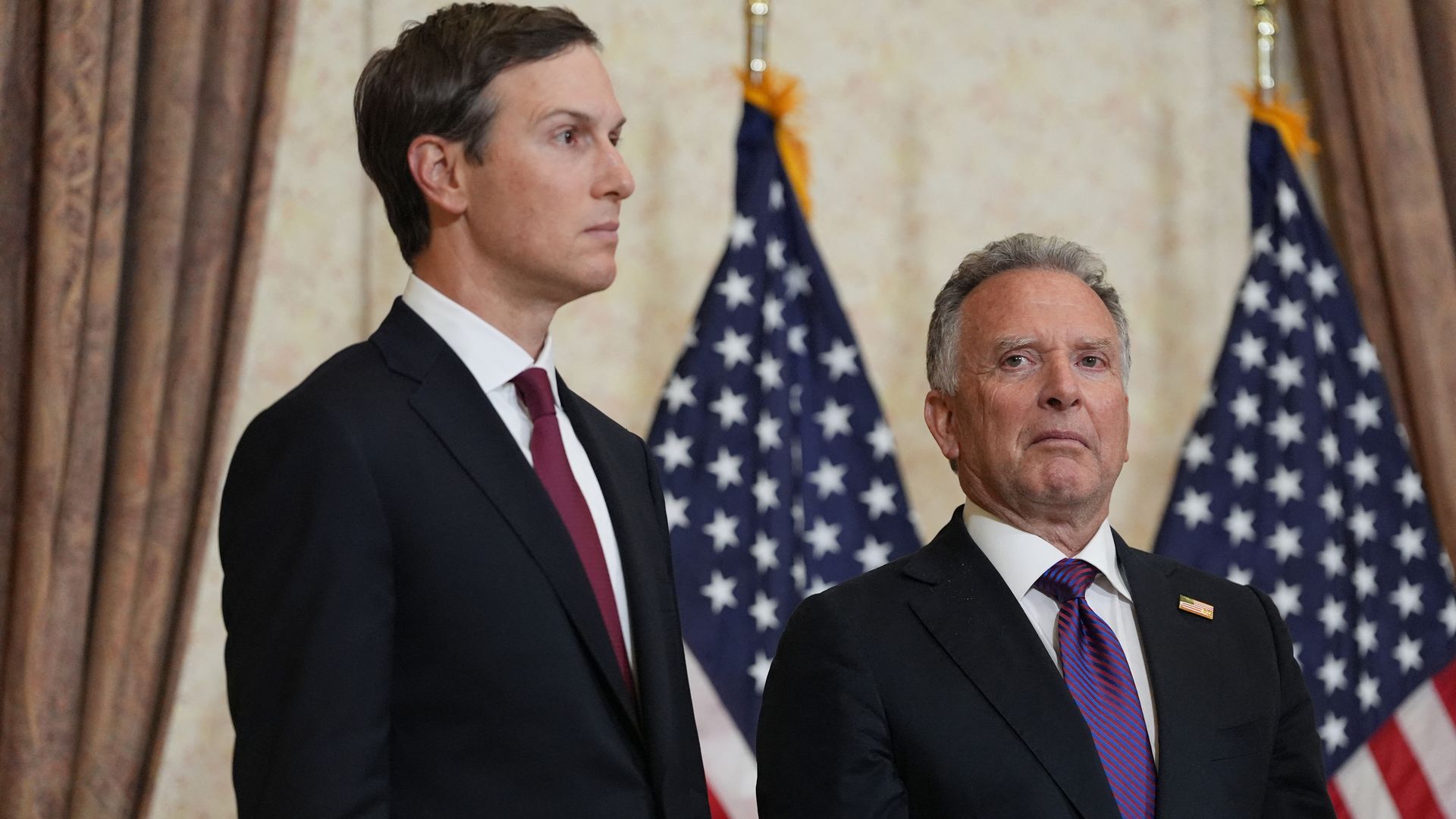 Jared Kushner and Steve Witkoff in front of American flags. 