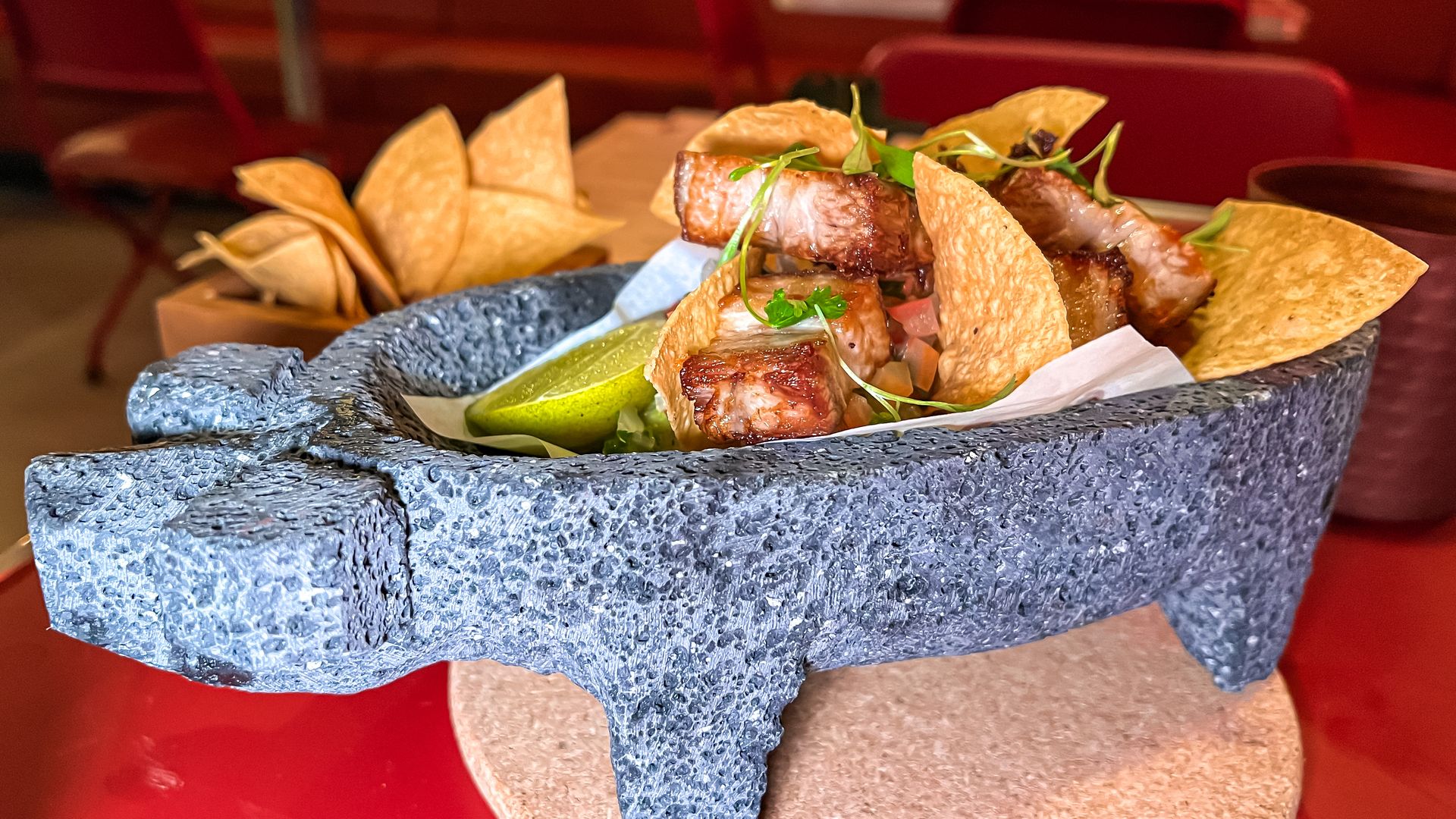 A pig-shaped molcajete filled with guacamole and pork pieces. 