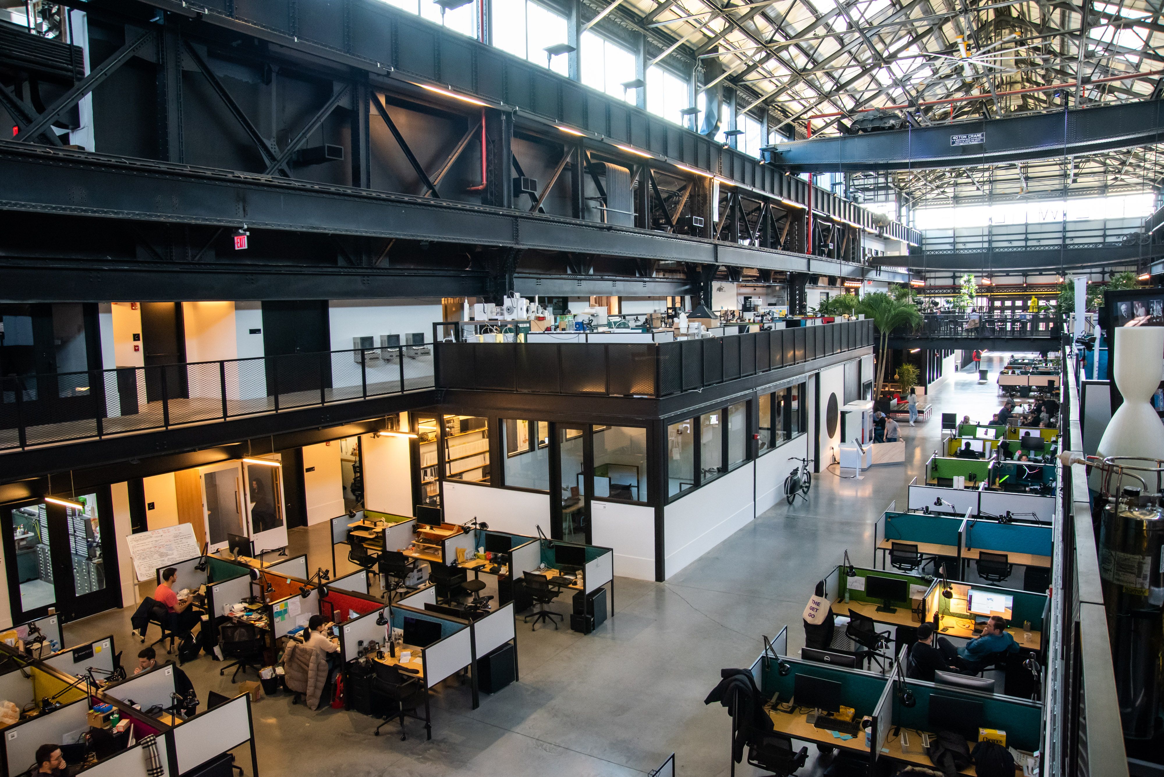 A birds-eye view of cubicles inside a modern warehouse.