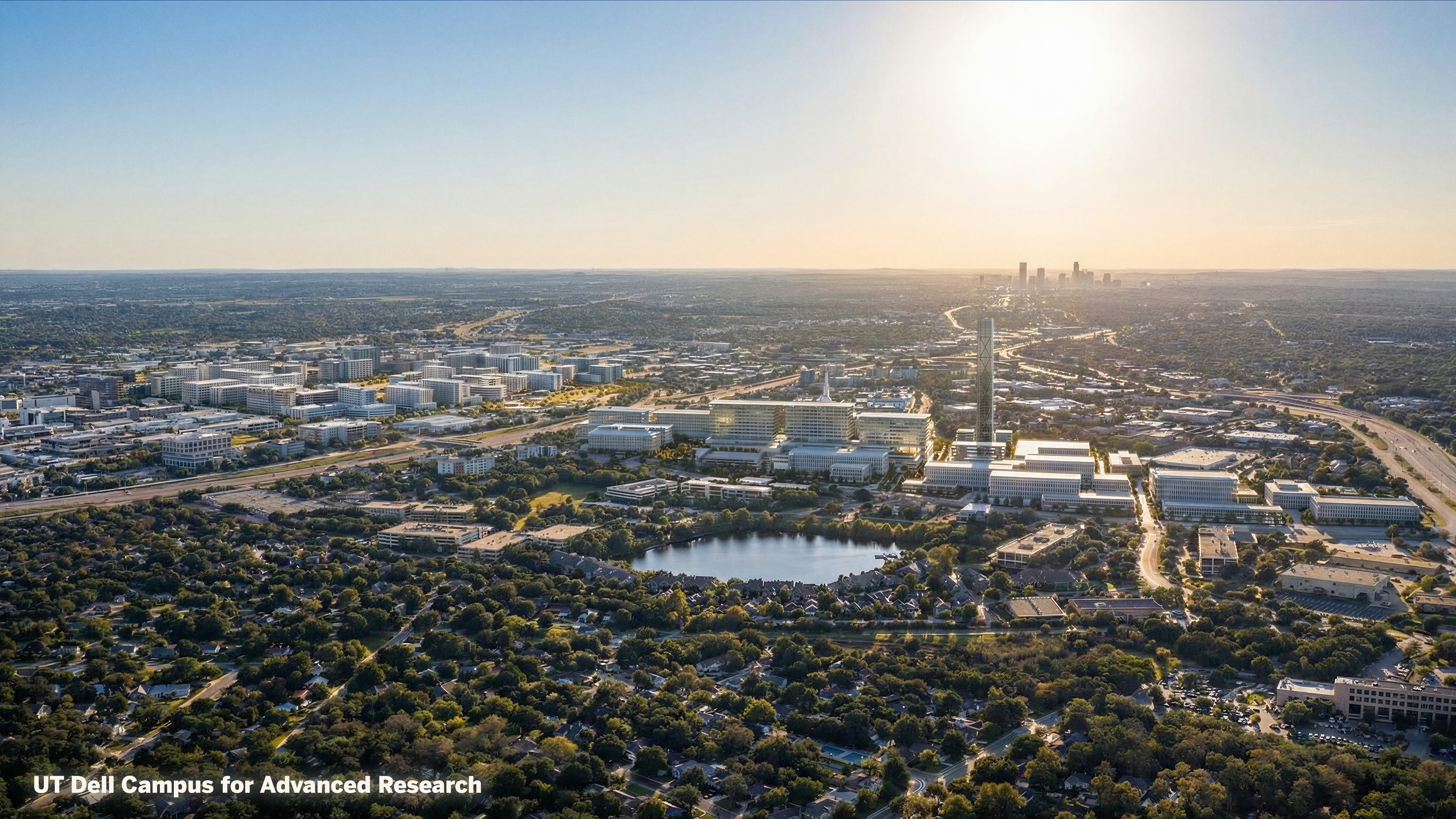 Aerial view of a sunlit city with a white, modern campus in the foreground, a tall tower, winding roads by a river, and a distant skyline on the horizon.