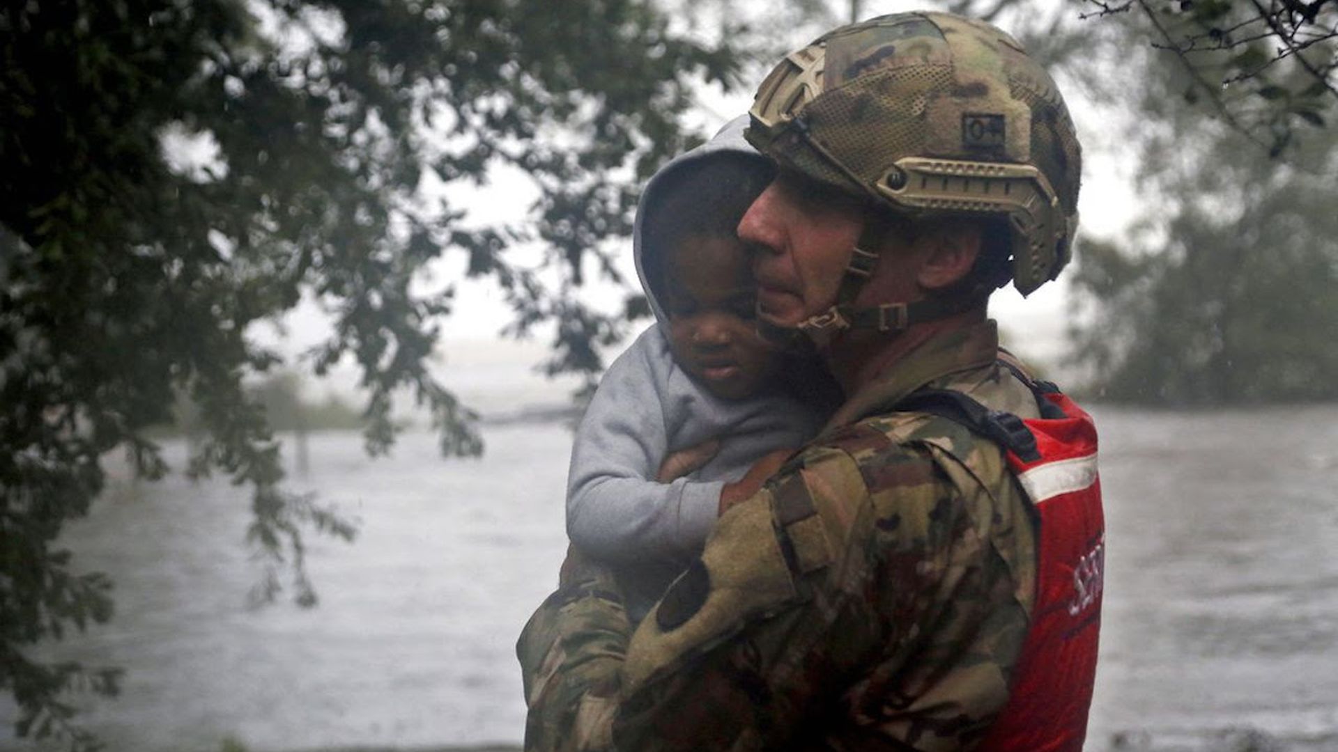 A National Guard member carries a child.