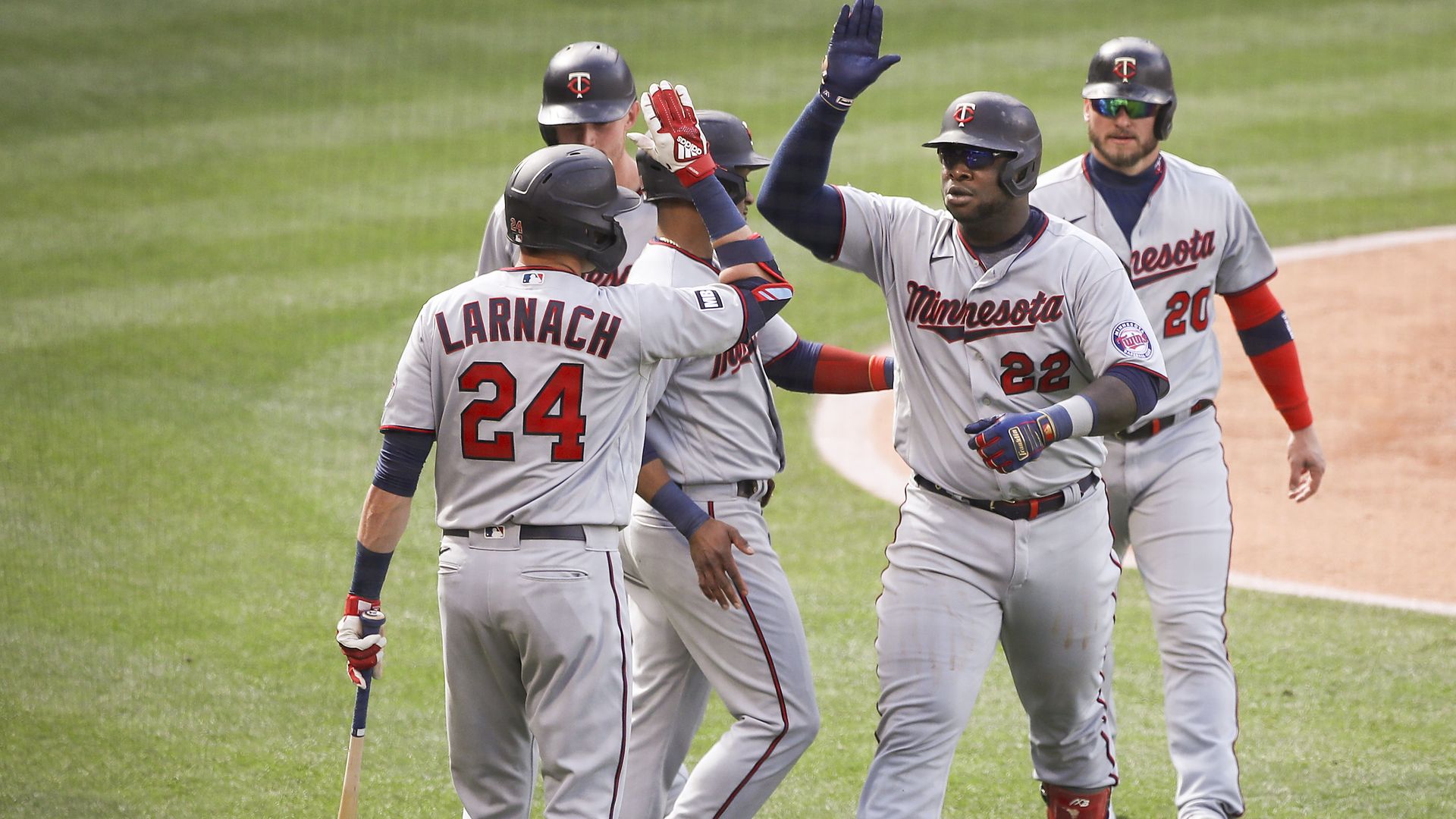 Miguel Sano high fives his Twins teammates on the field 
