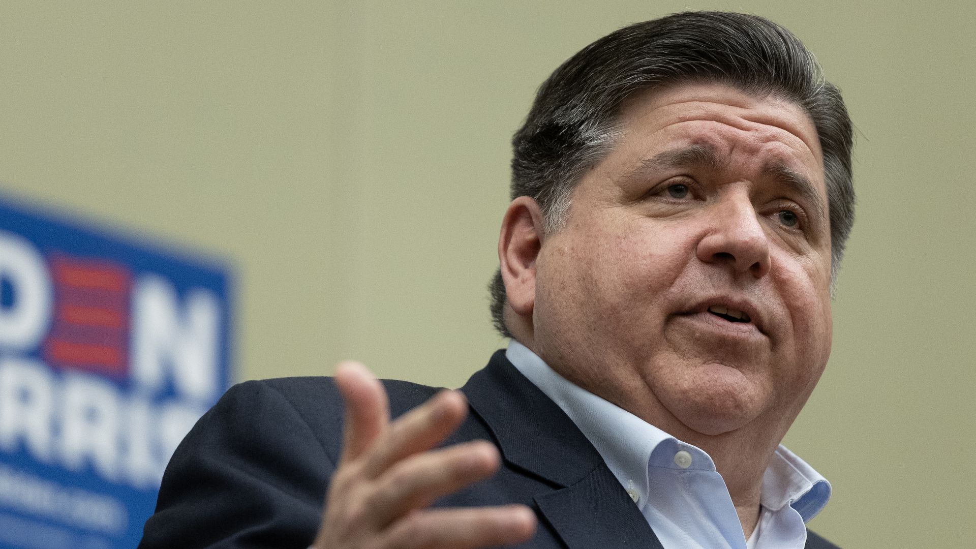 Photo of a man talking to a crowd at a podium 