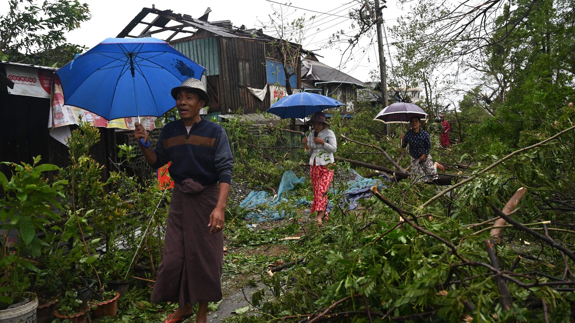 Local residents walk past fallen trees after Cyclone Mocha's crashed ashore in Kyauktaw in the northern part of Myanmar's Rakhine state on May 14. Photo: Sai Aung Main/AFP via Getty Images