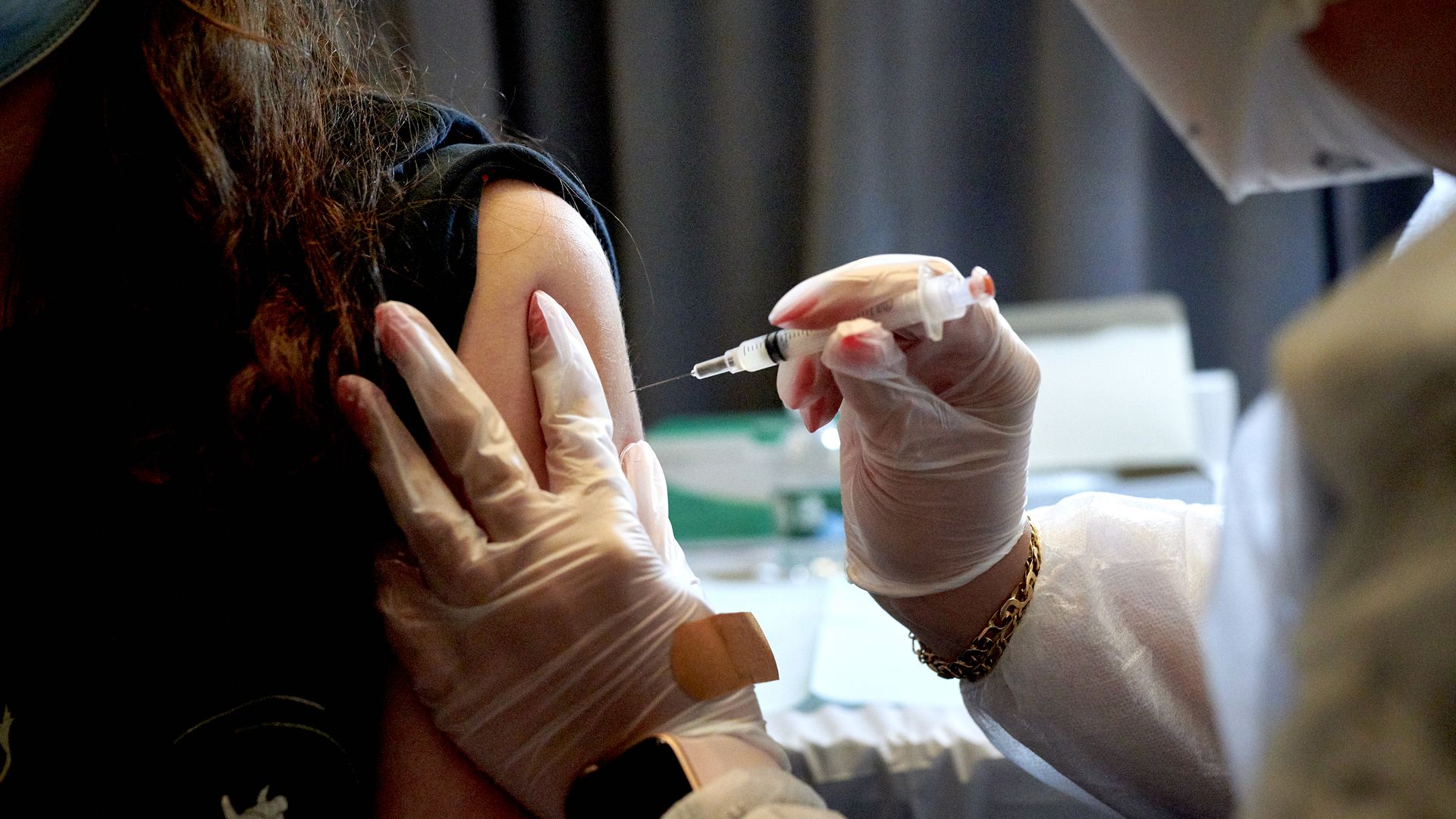 Picture of a health care worker administering a Moderna vaccine to a patient