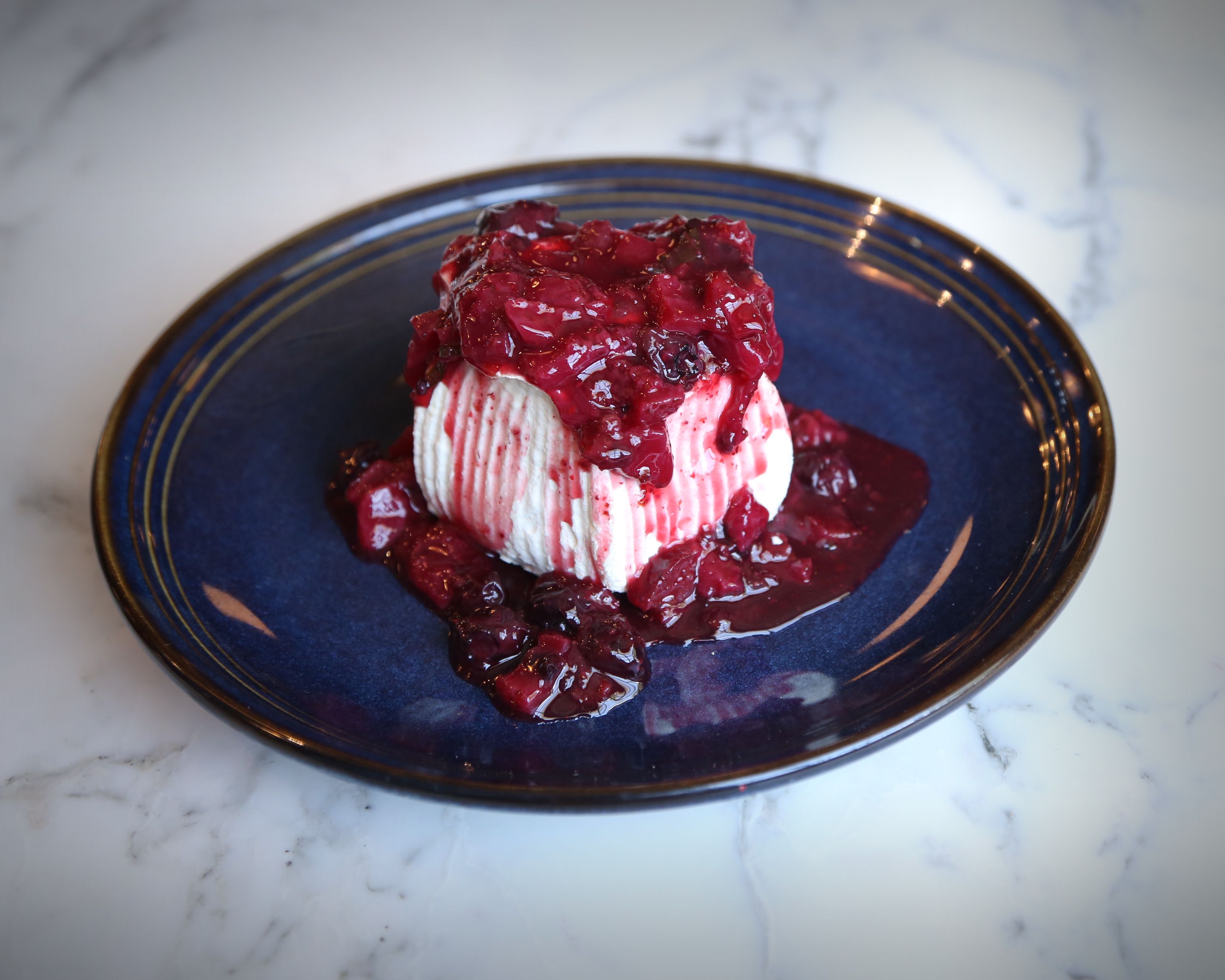 Photo shows a pavlova on a blue plate