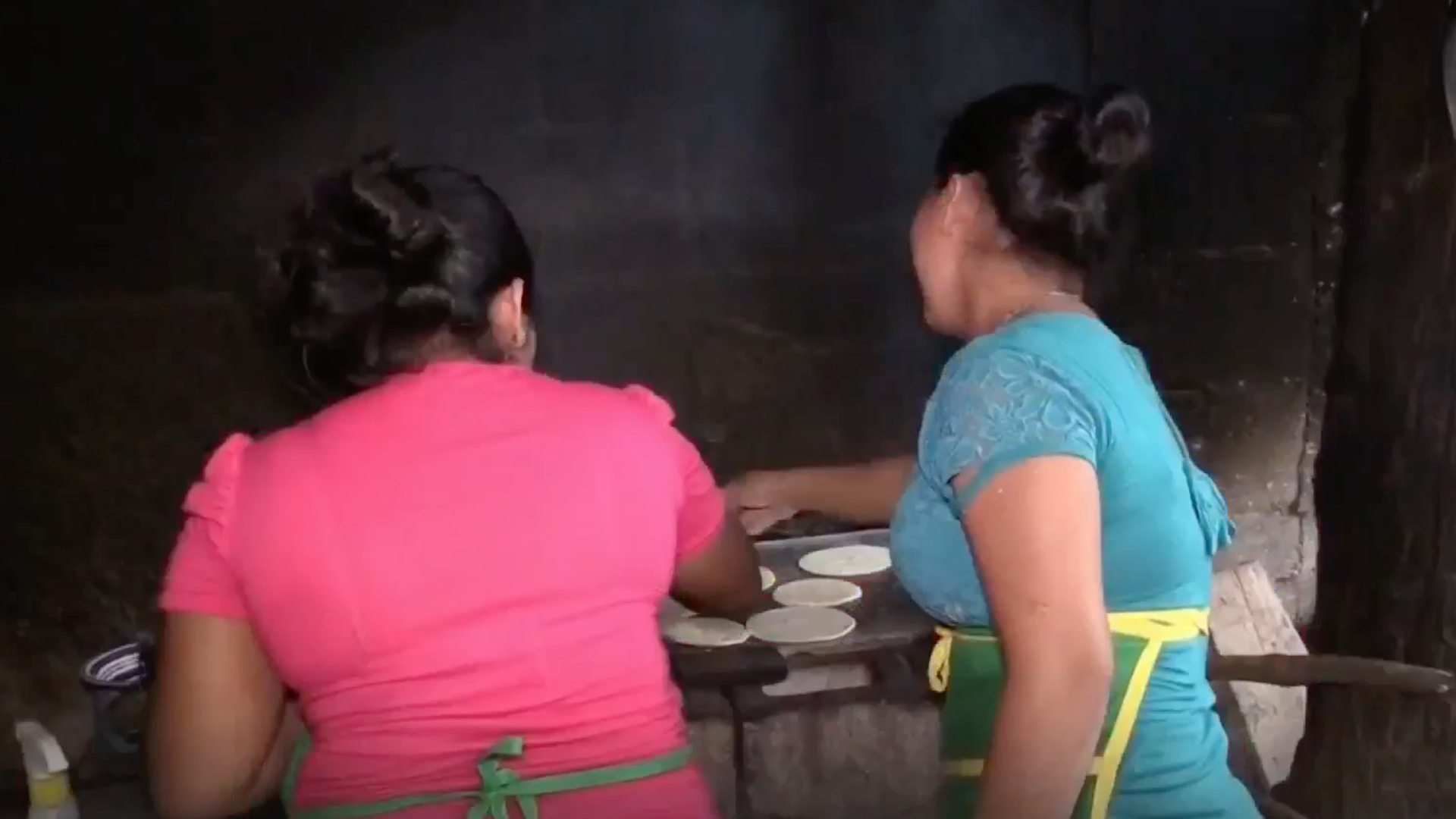 Two young Indigenous women working in a tortillería in Guatemala. 
