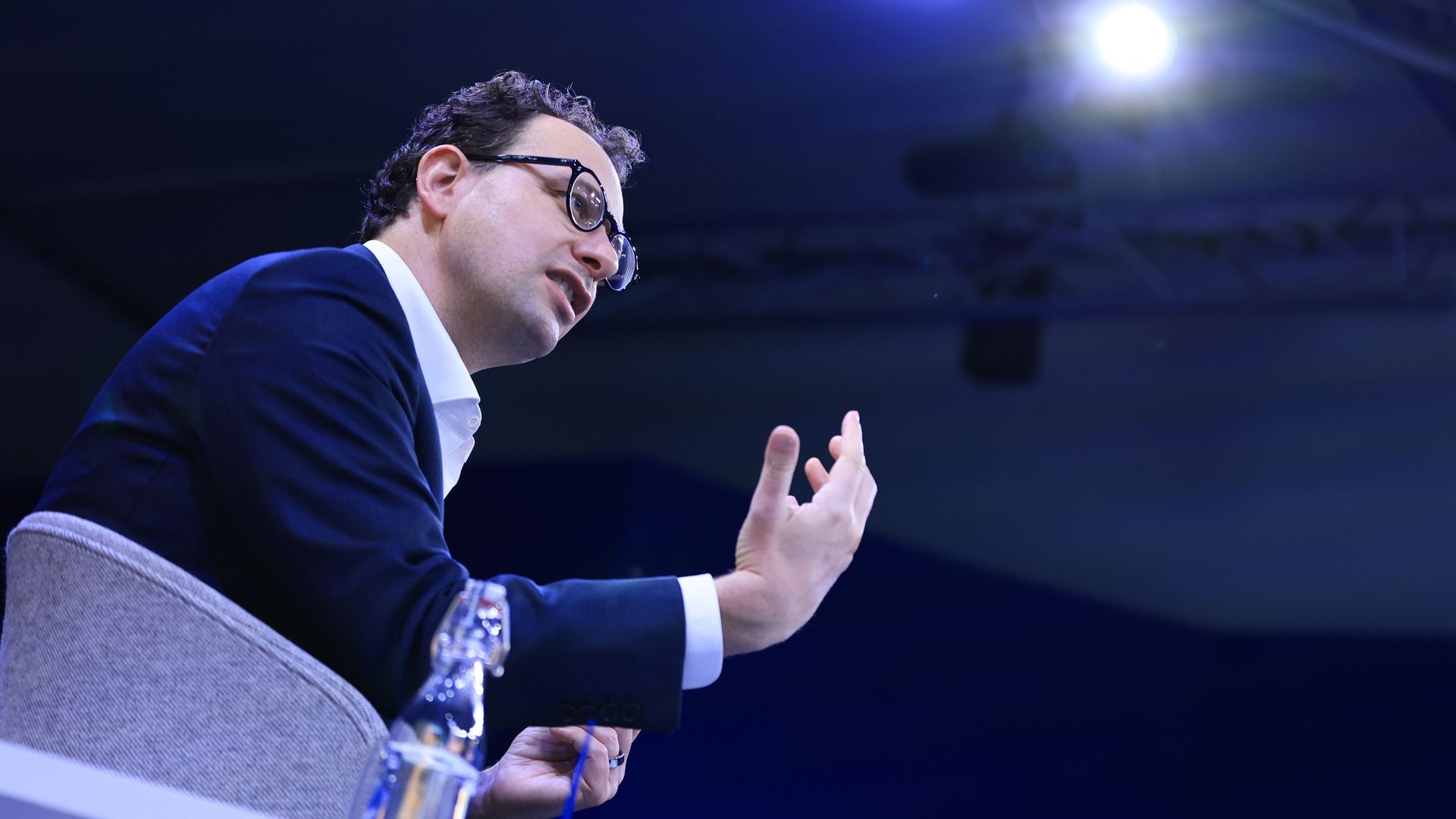 Anthropic CEO Dario Amodei, seated and gesturing upward with his right hand.