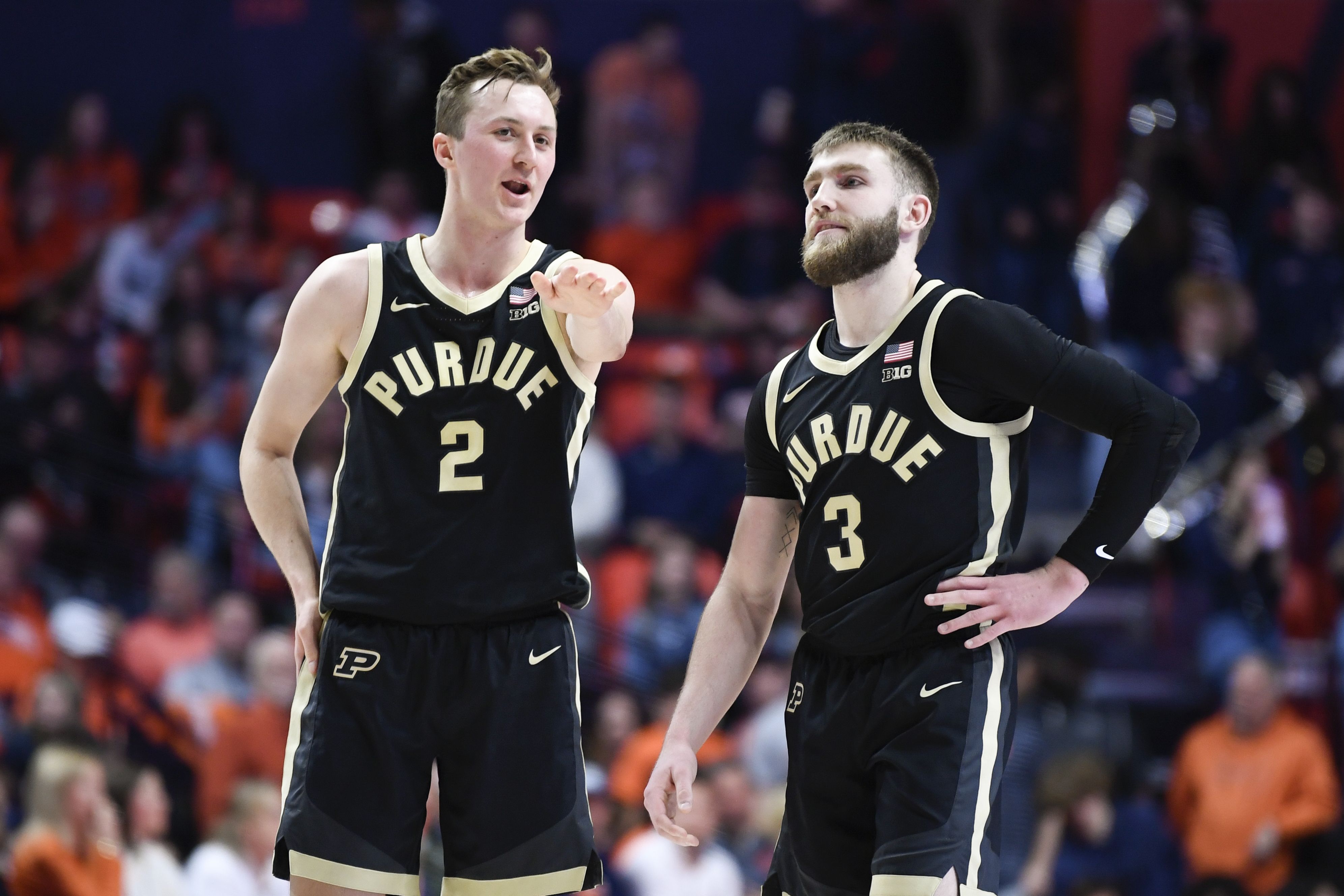 Photo of two basketball players on the court during a game. 