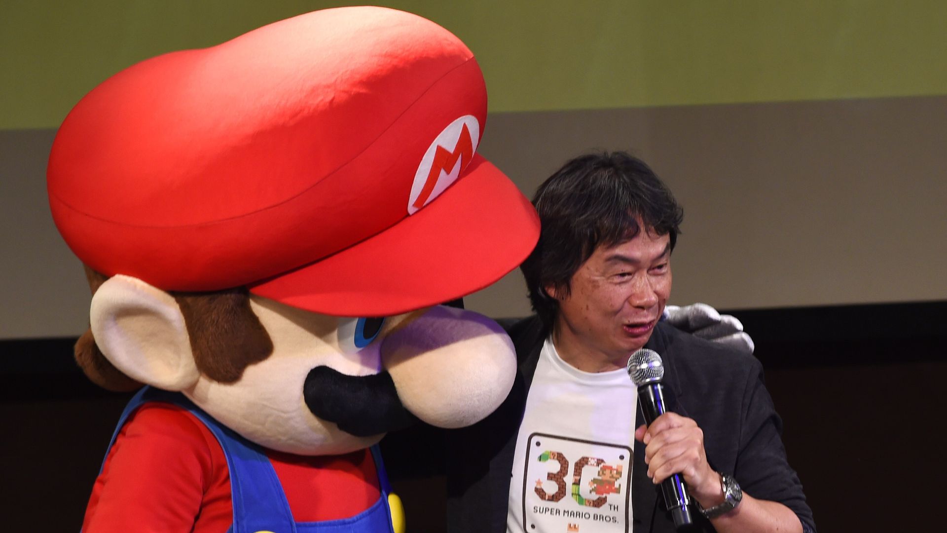 Shigeru Miyamoto with a giant Super Mario doll.