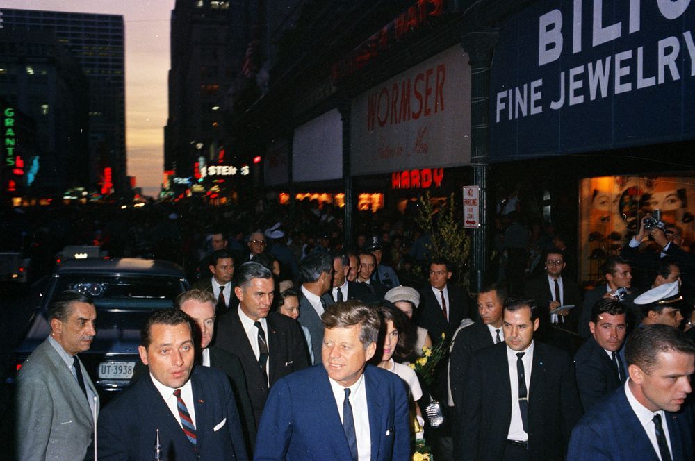 President John F. Kennedy and First Lady Jacqueline Kennedy (partially hidden) arrive at the Rice Hotel in Houston.