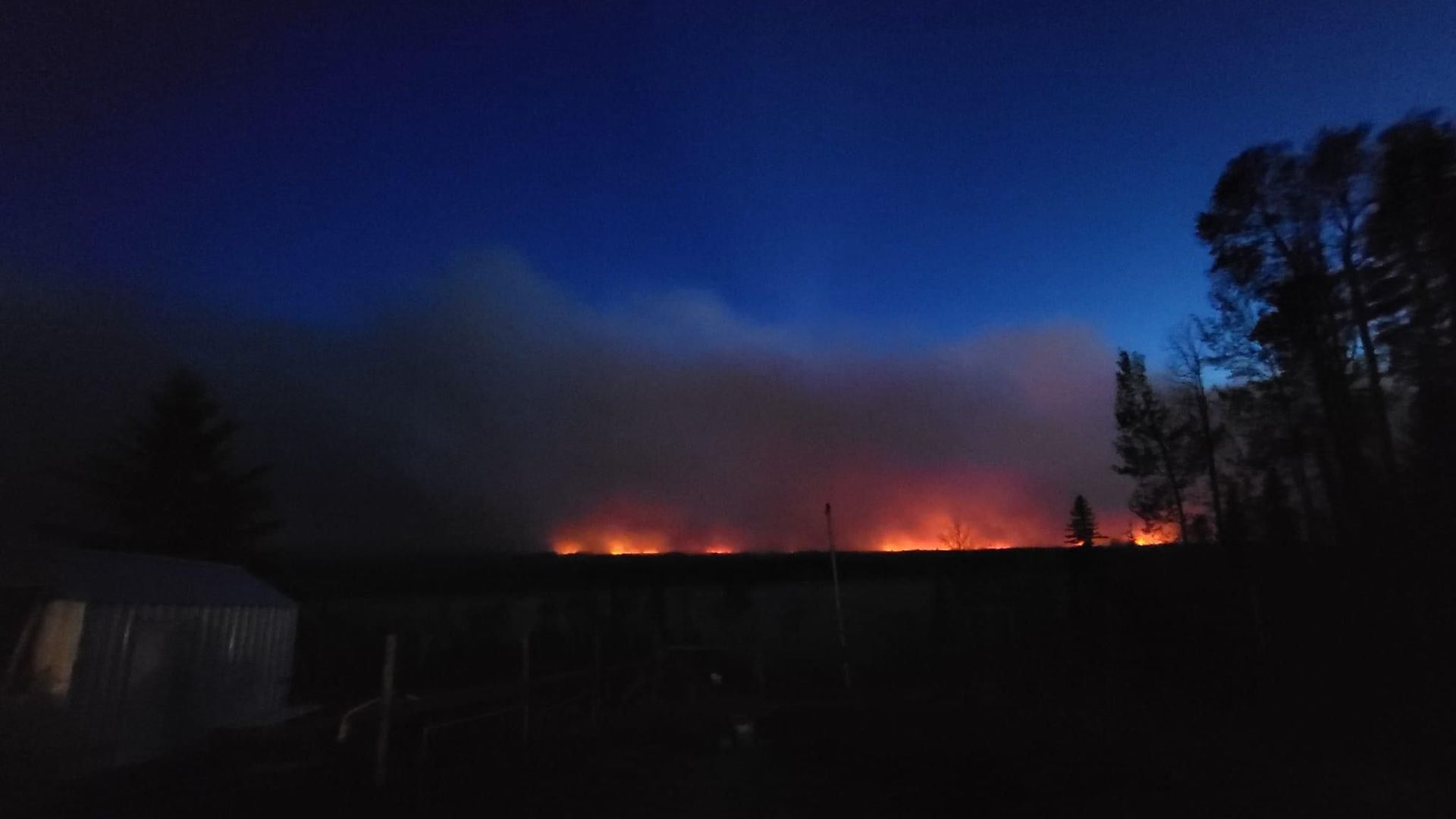 Flames from a wildfire in Canada are seen against a dark sky
