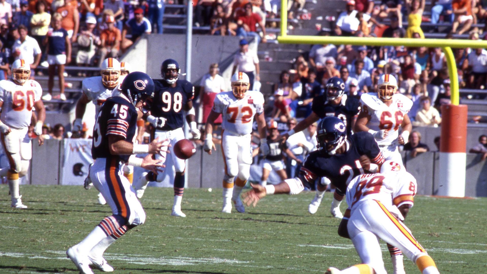 Photo of football players in uniform catching the ball during a game. 