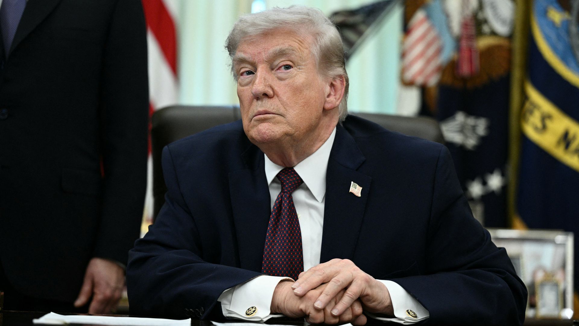 President Donald Trump sitting behind his desk.