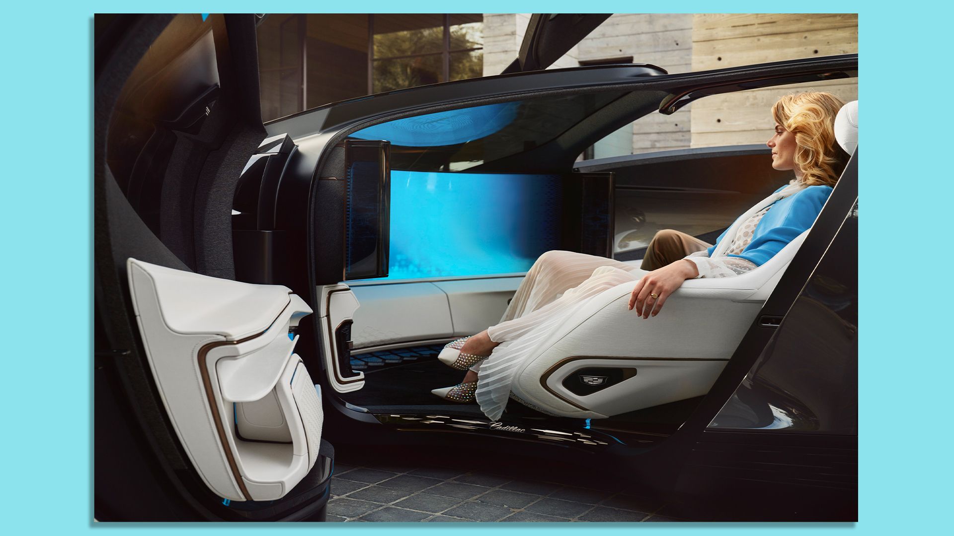A woman relaxing inside Cadillac's InnerSpace concept car, with a massive curved screen and reclining seats