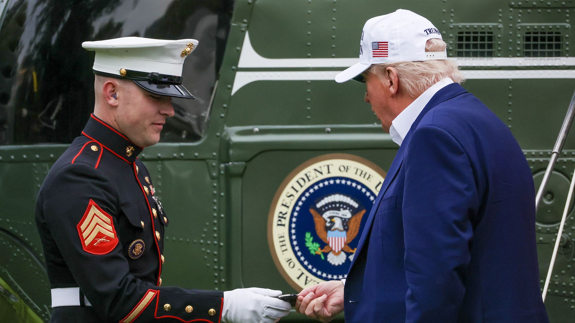 Trump hands something to a marine 