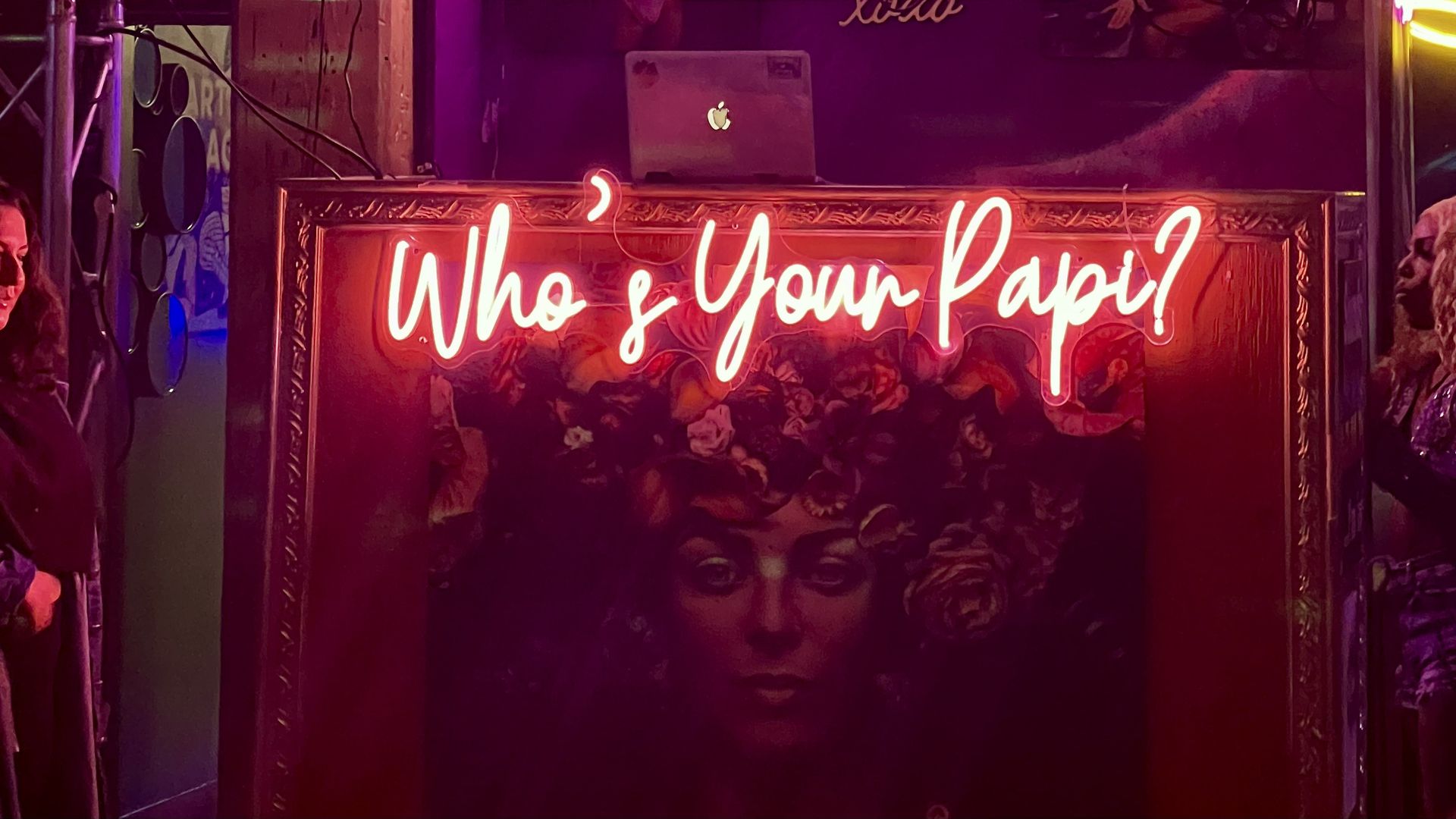 A neon sign that says "Who's your Papi" in red