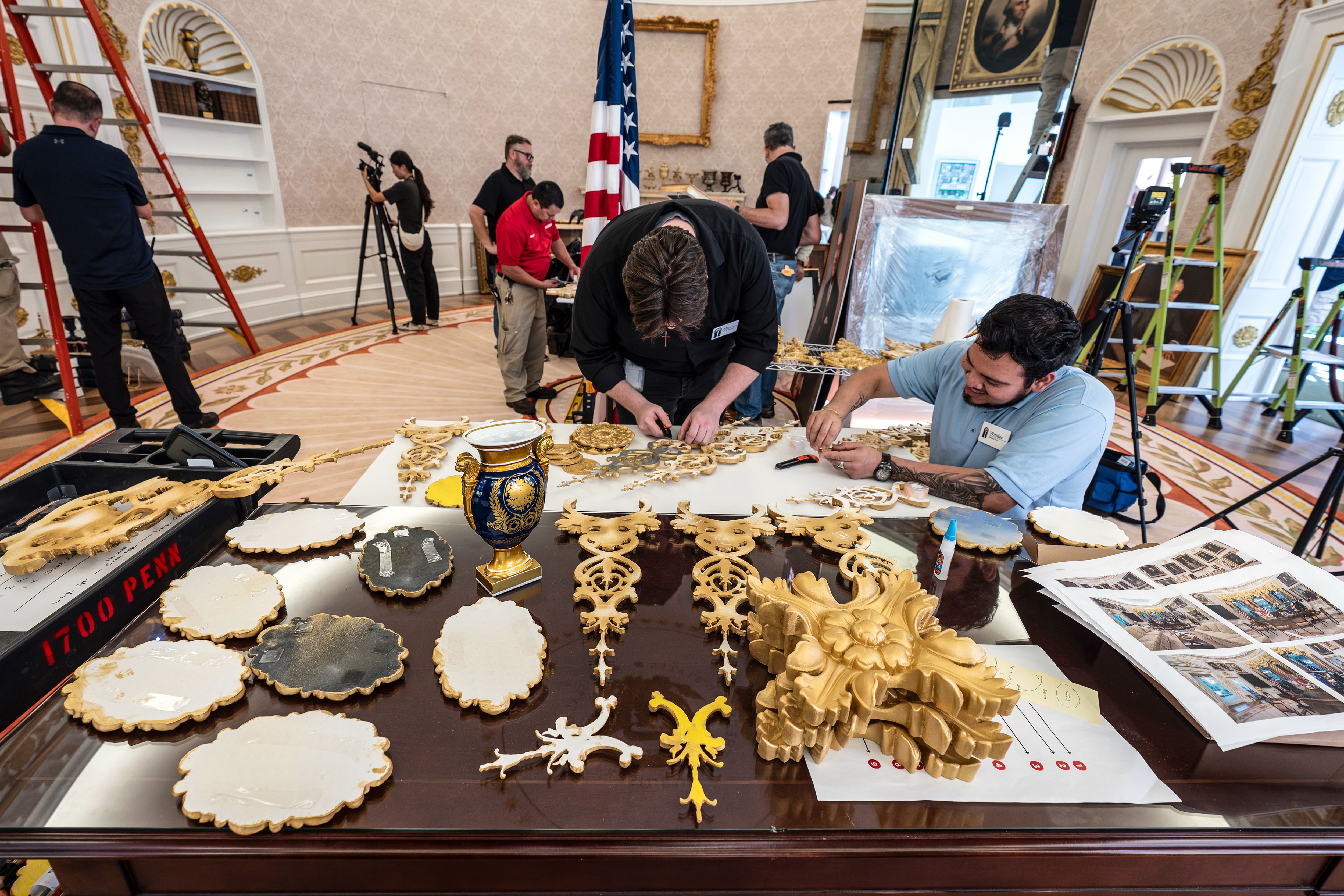 A replica of President Trump's Oval Office is updated to the current decor by workers at The People's House museum exhibit in D.C.