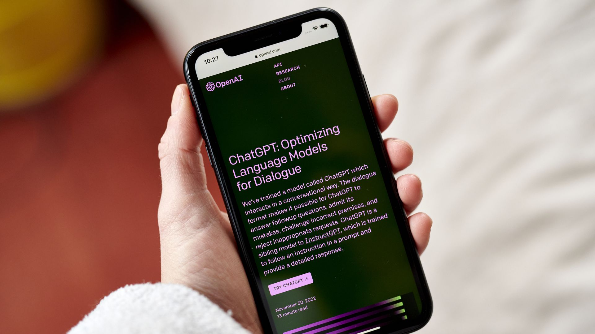 A hand holds a smart phone with ChatGPT opened.