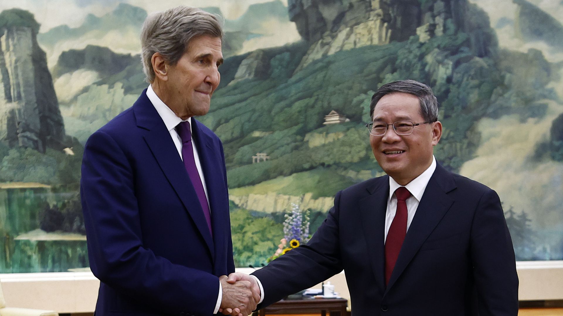 Photo of U.S. climate envoy John Kerry greeted by Chinese Premier Li Qiang before a meeting in the Great Hall of the People on July 18 in Beijing, China. 
