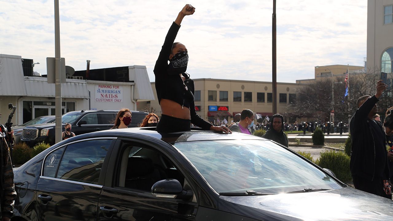 A woman rides in a car with her fist in the air during a march for Breonna Taylor in Louisville, Kentucky. 