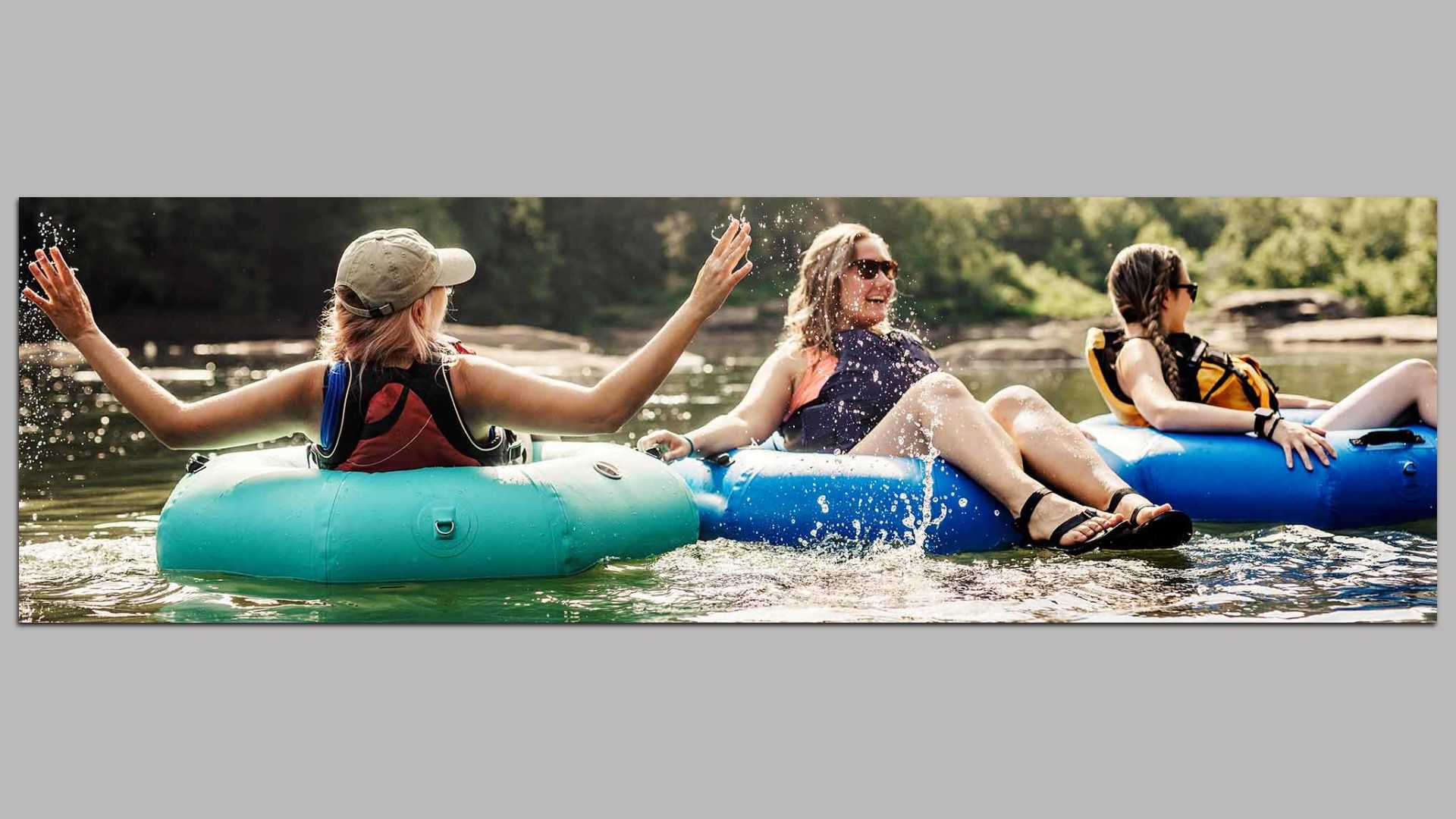Three women float in tubes on the James 
