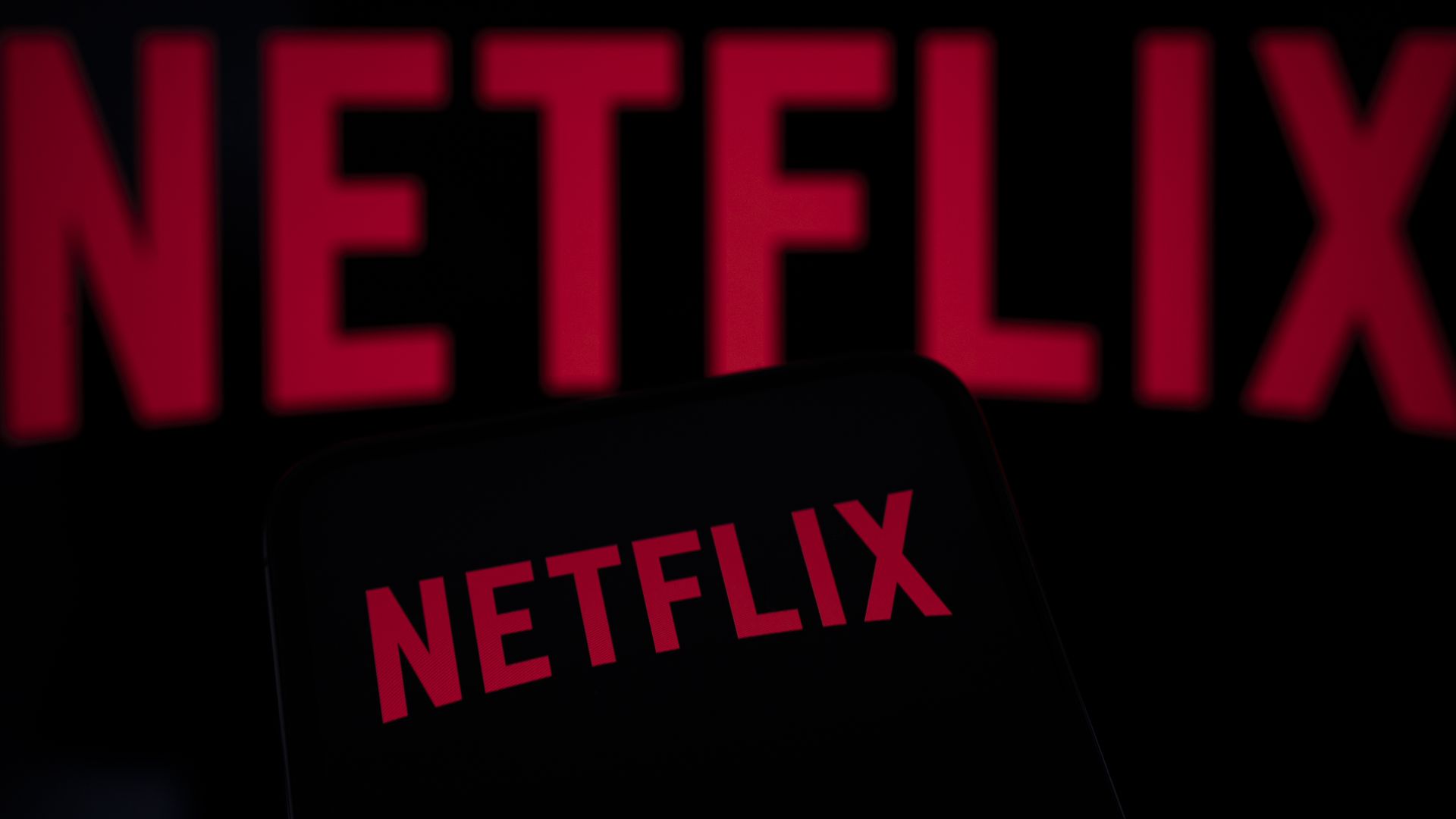 In this photo illustration, the Netflix logo appears on a cell phone with another Netflix logo in the background in Creteil, France, on December 10, 2025. (Photo by Samuel Boivin/NurPhoto via Getty Images)
