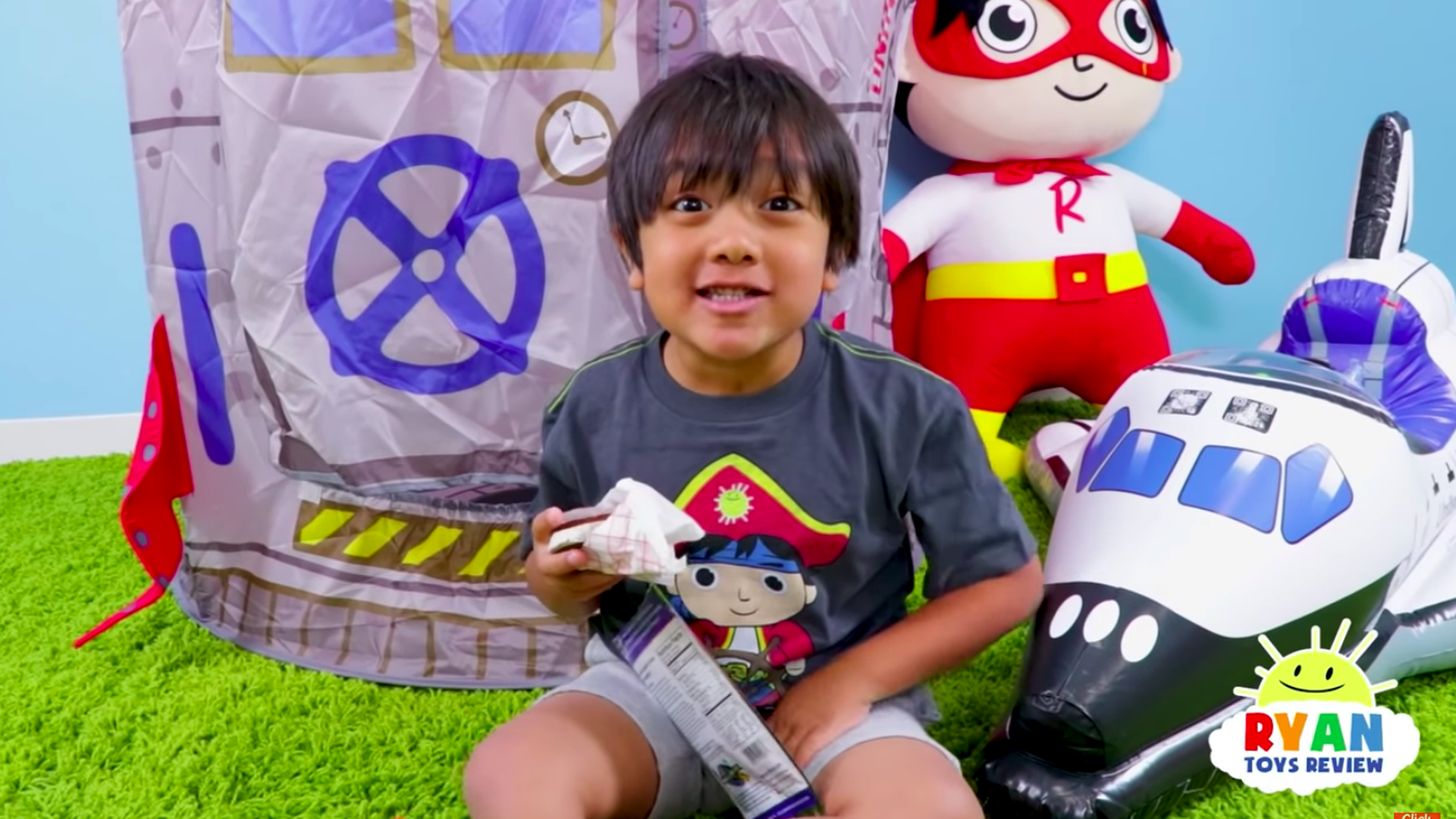 A kid holding a toy smiles at the camera