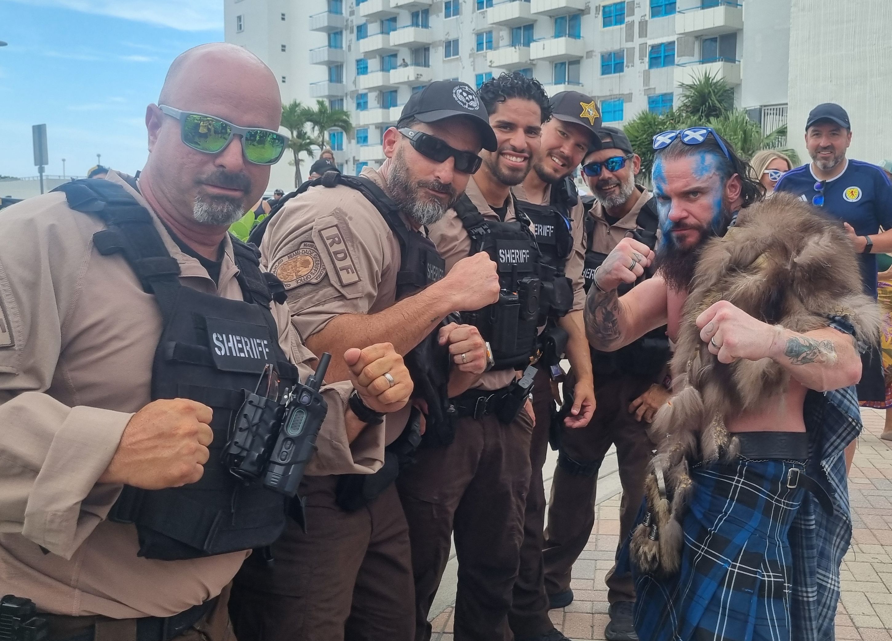 Miami-Dade Sheriff's Office deputies pose for a photo with a Scottish fan.