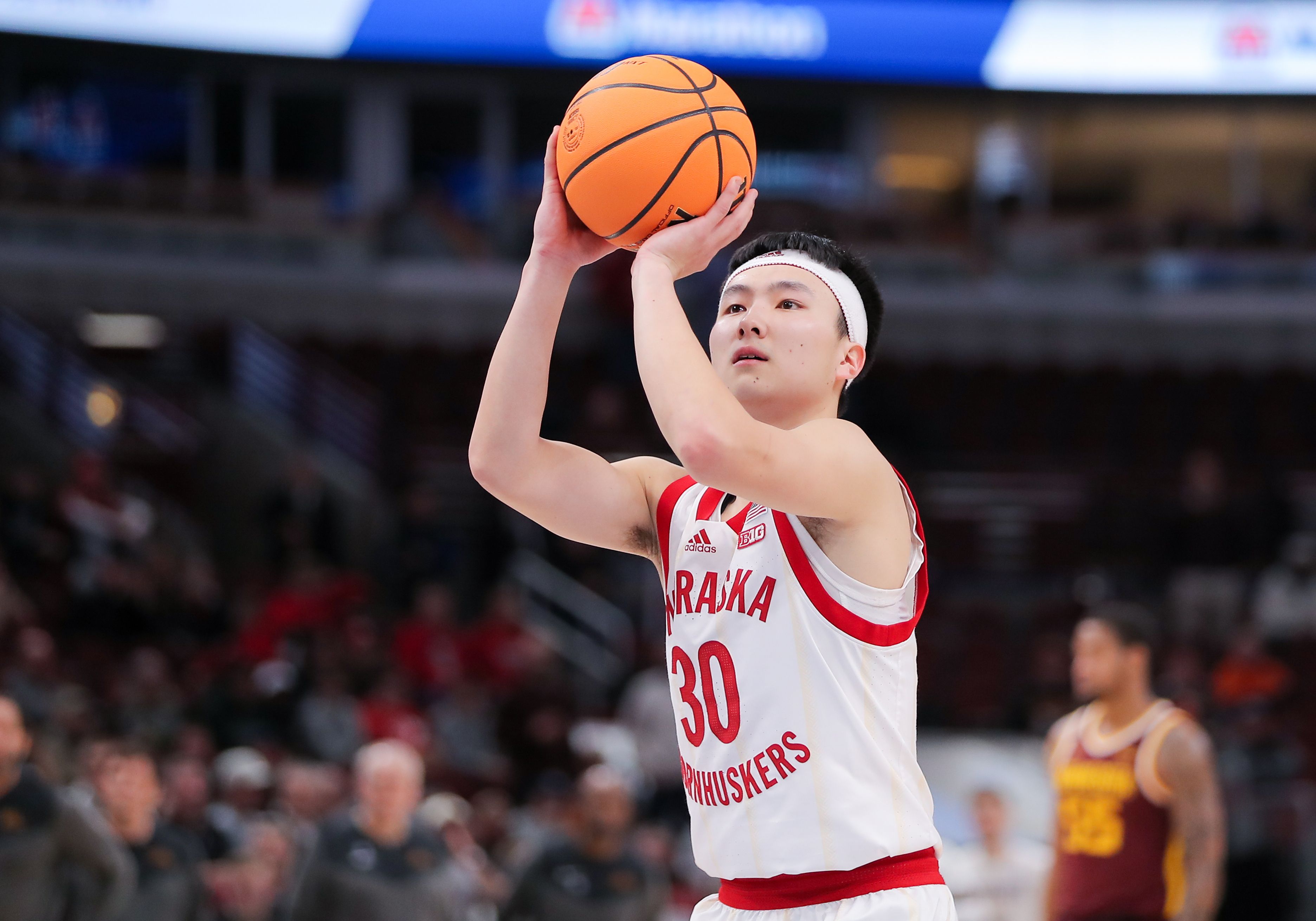 Photo of a man shooting a basketball on the court