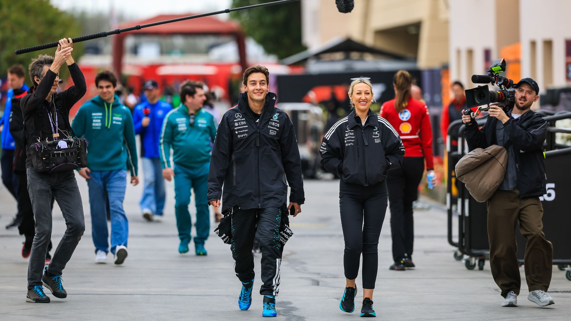 Mercedes F1 driver George Russell walks in the paddock alongside the Netflix filming crew during day one of F1 Testing at Bahrain International Circuit.
