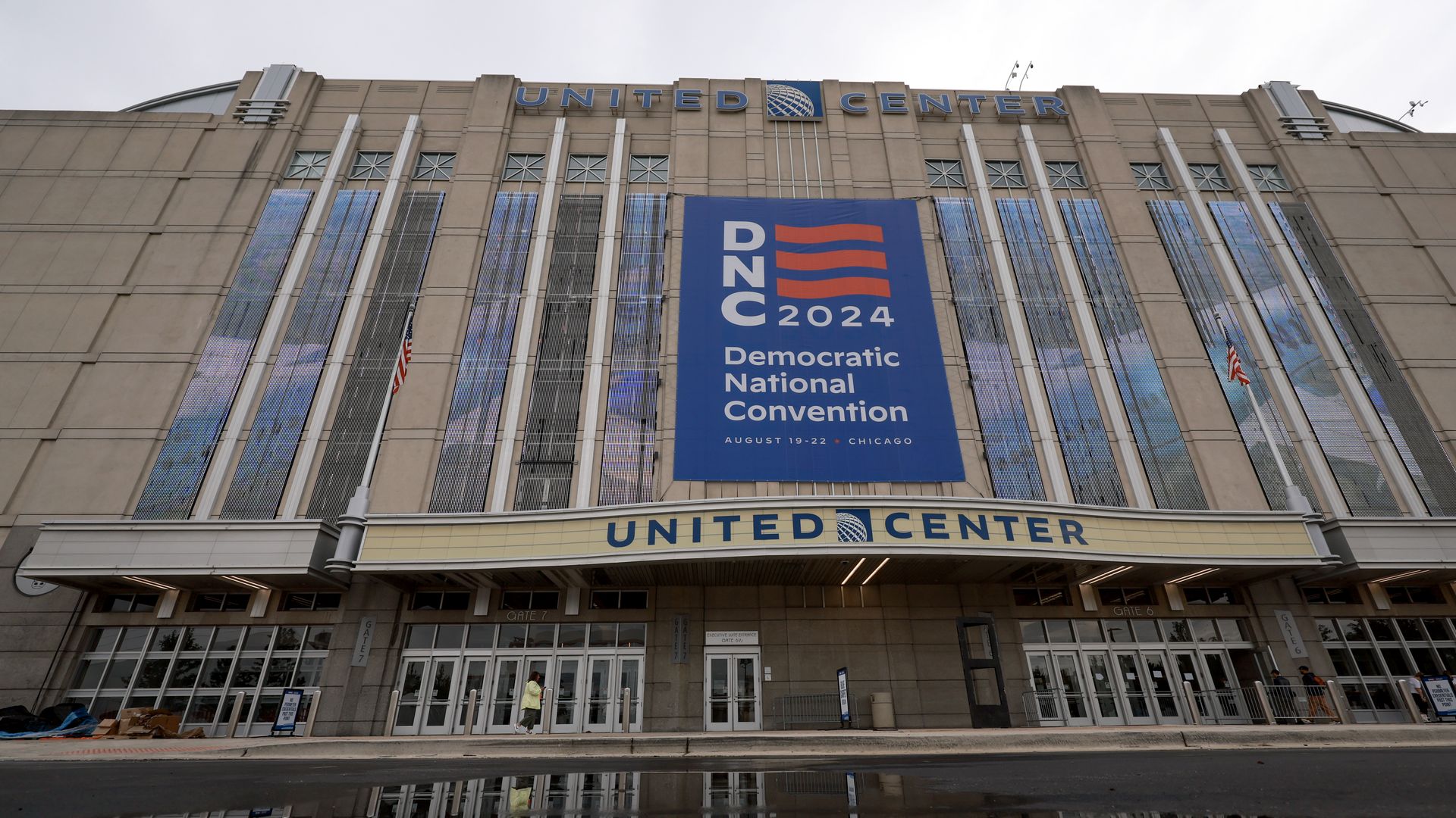 outside the entrance to the united center, with a DNC 2024 banner hanging on the building