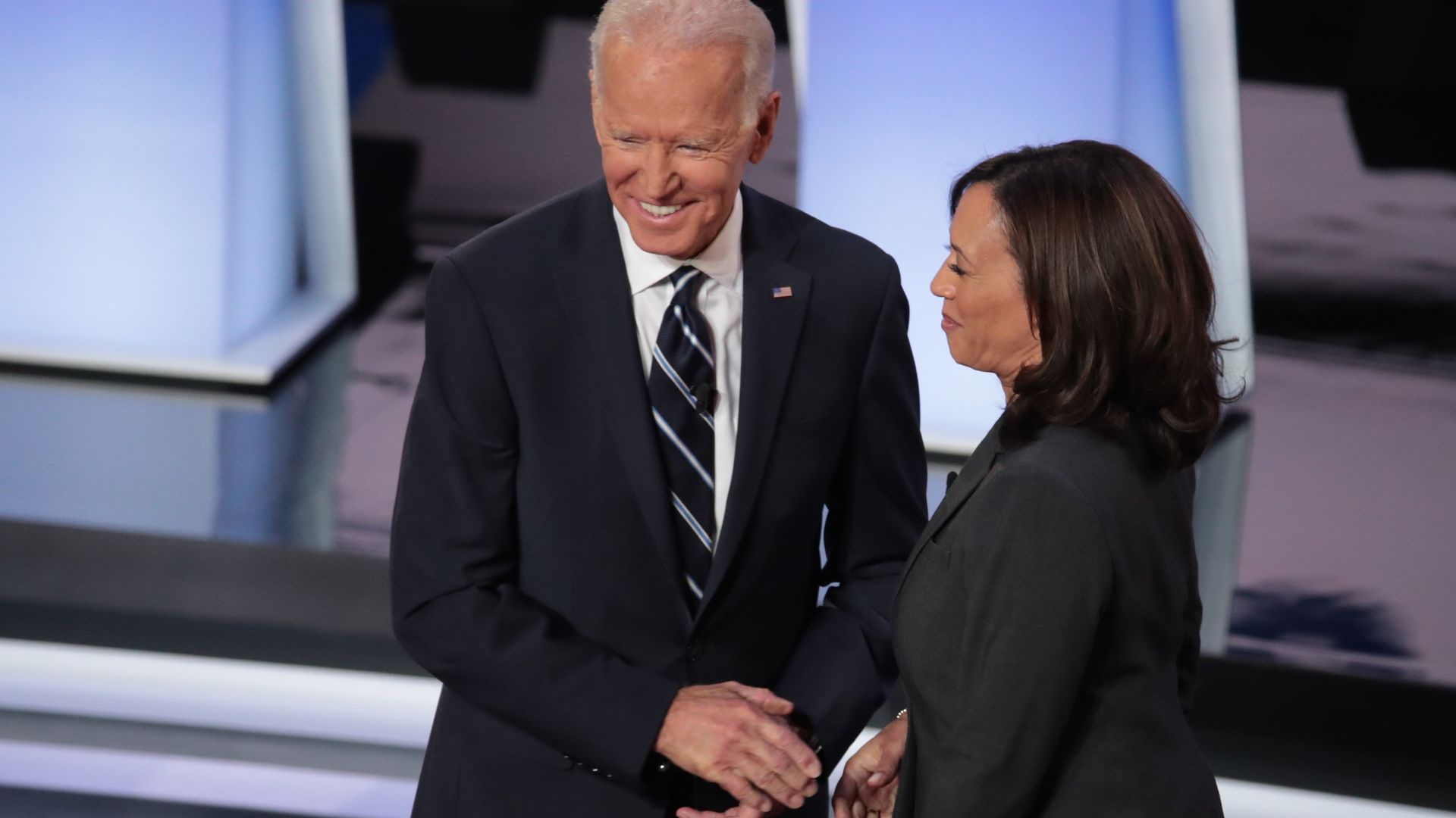 In this image, Biden and Harris shake hands and smile.