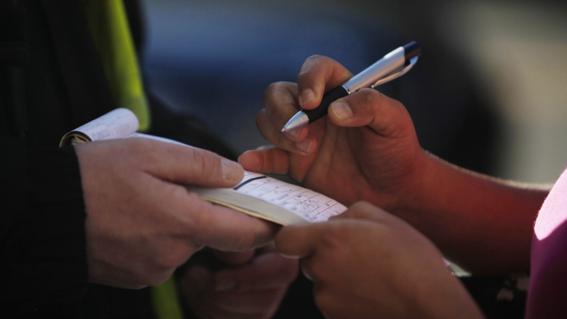someone signs a booklet