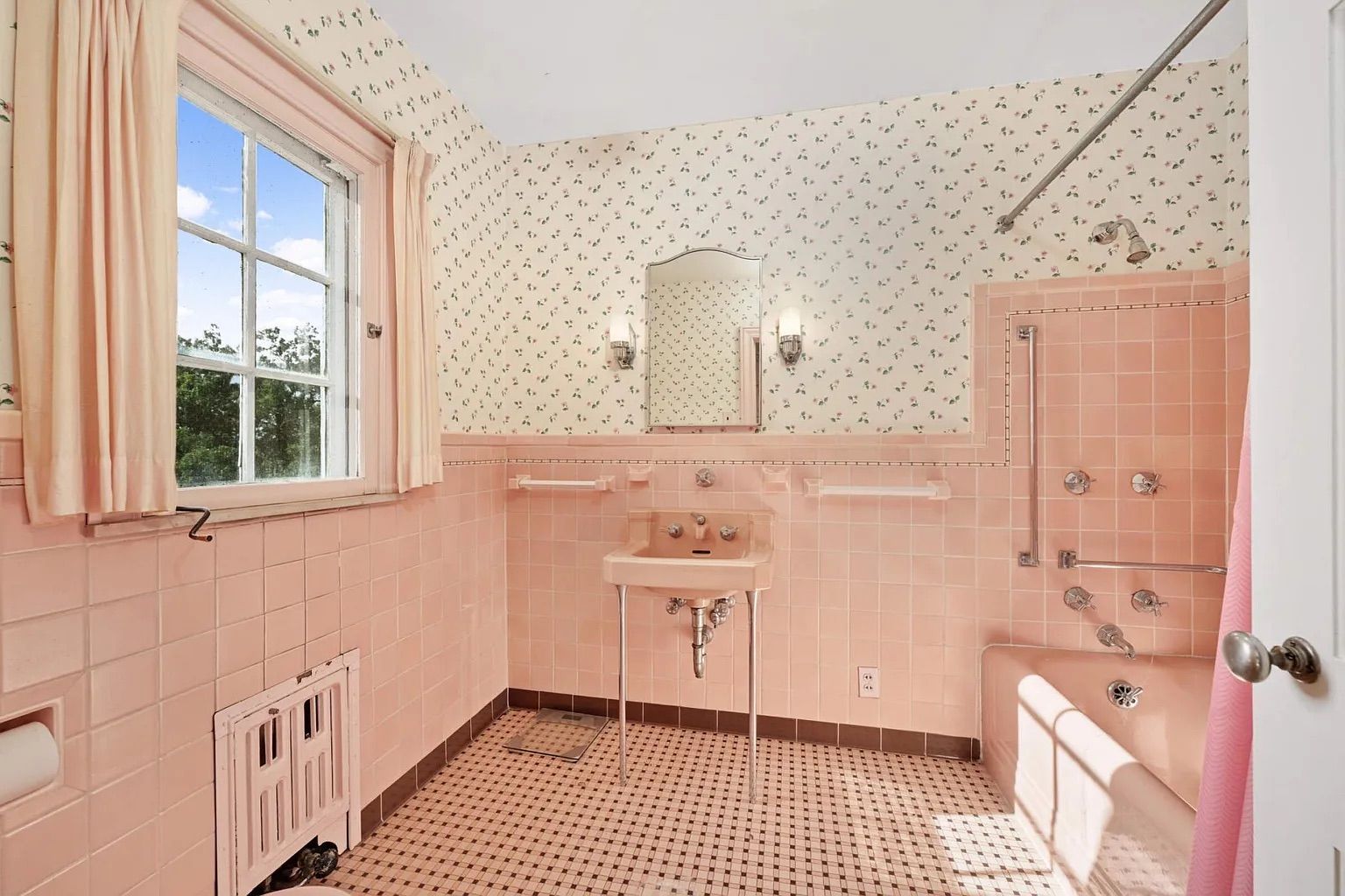 A bathroom with pink tiled walls.