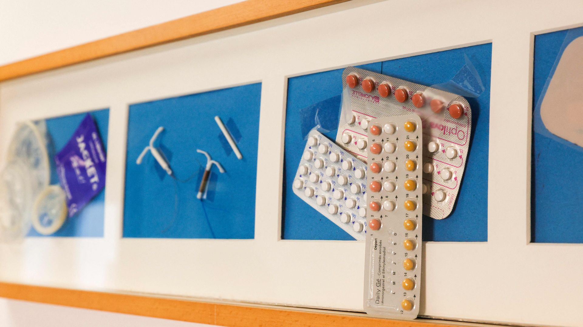 Picture of a wall with different types of birth control taped to the wall