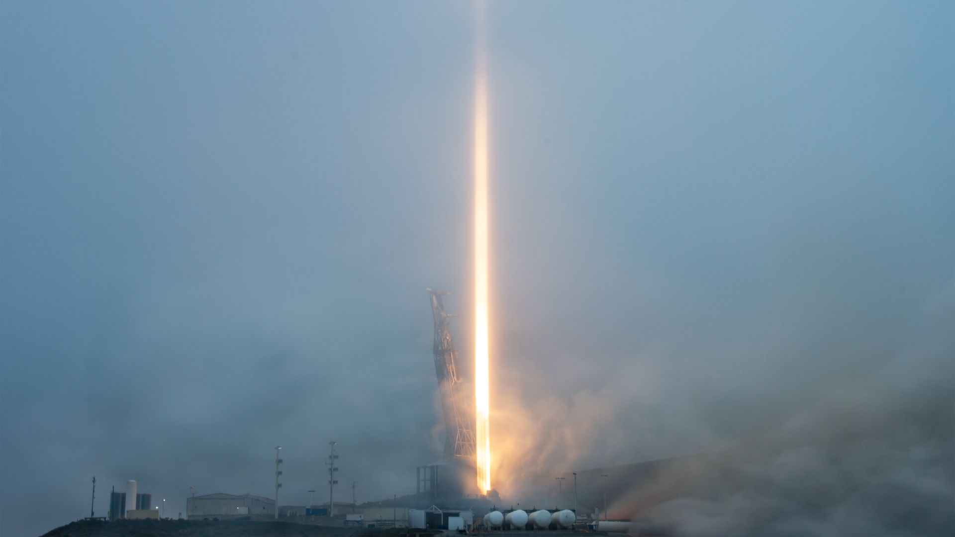 A dimly lit rocket launch, with a large orange streak through the middle.