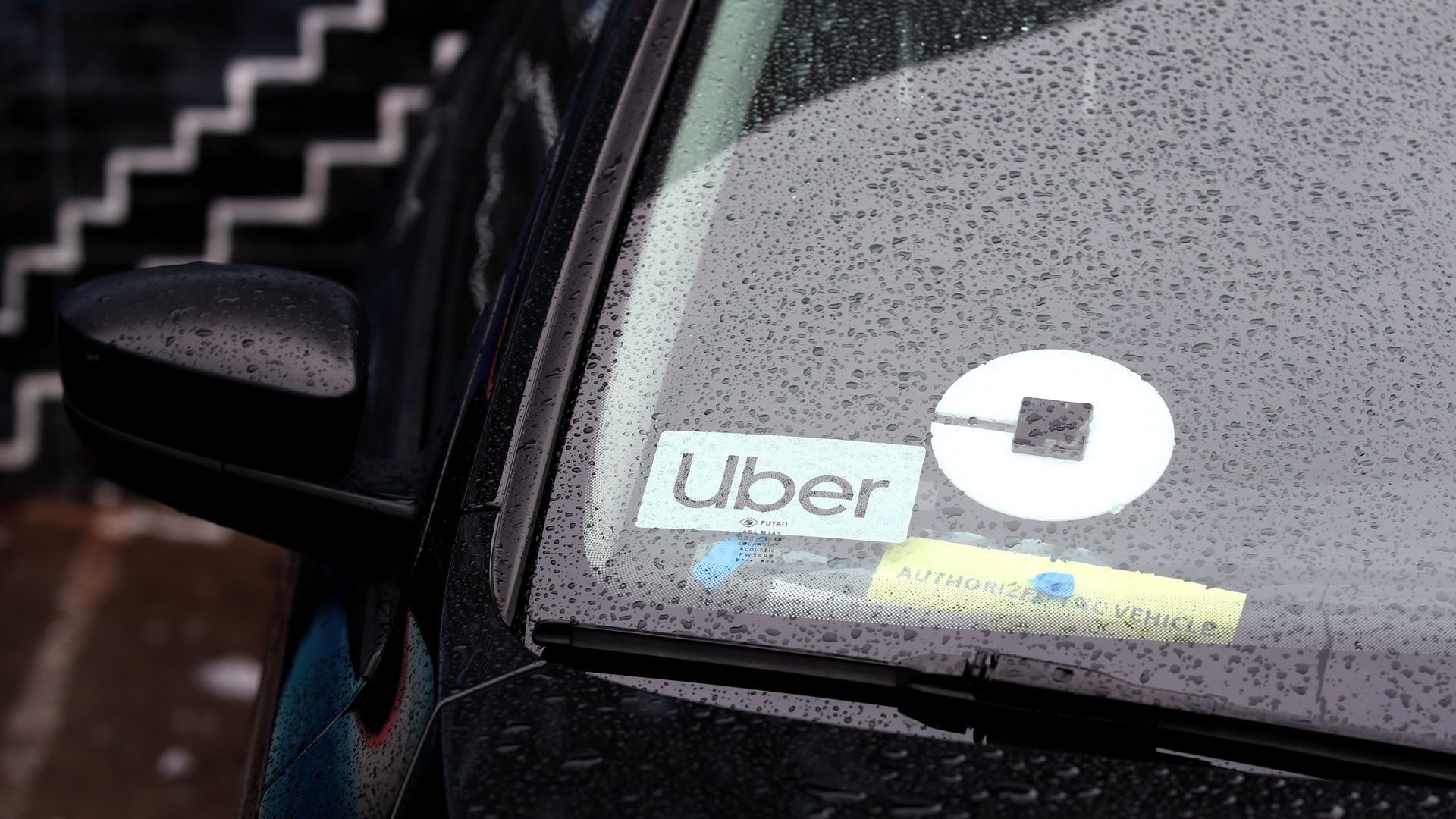 Photo of car with Uber sticker in the windshield.
