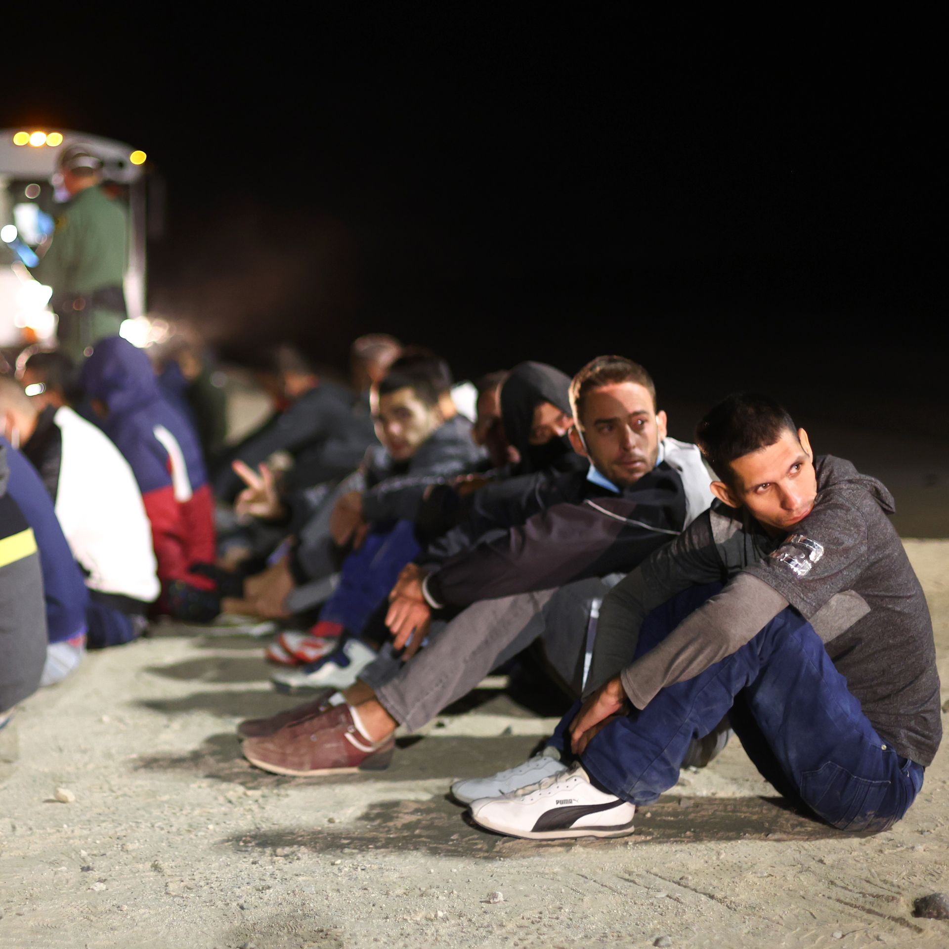Immigrants wait to board a U.S. Border Patrol bus to be taken for processing after crossing the border from Mexico