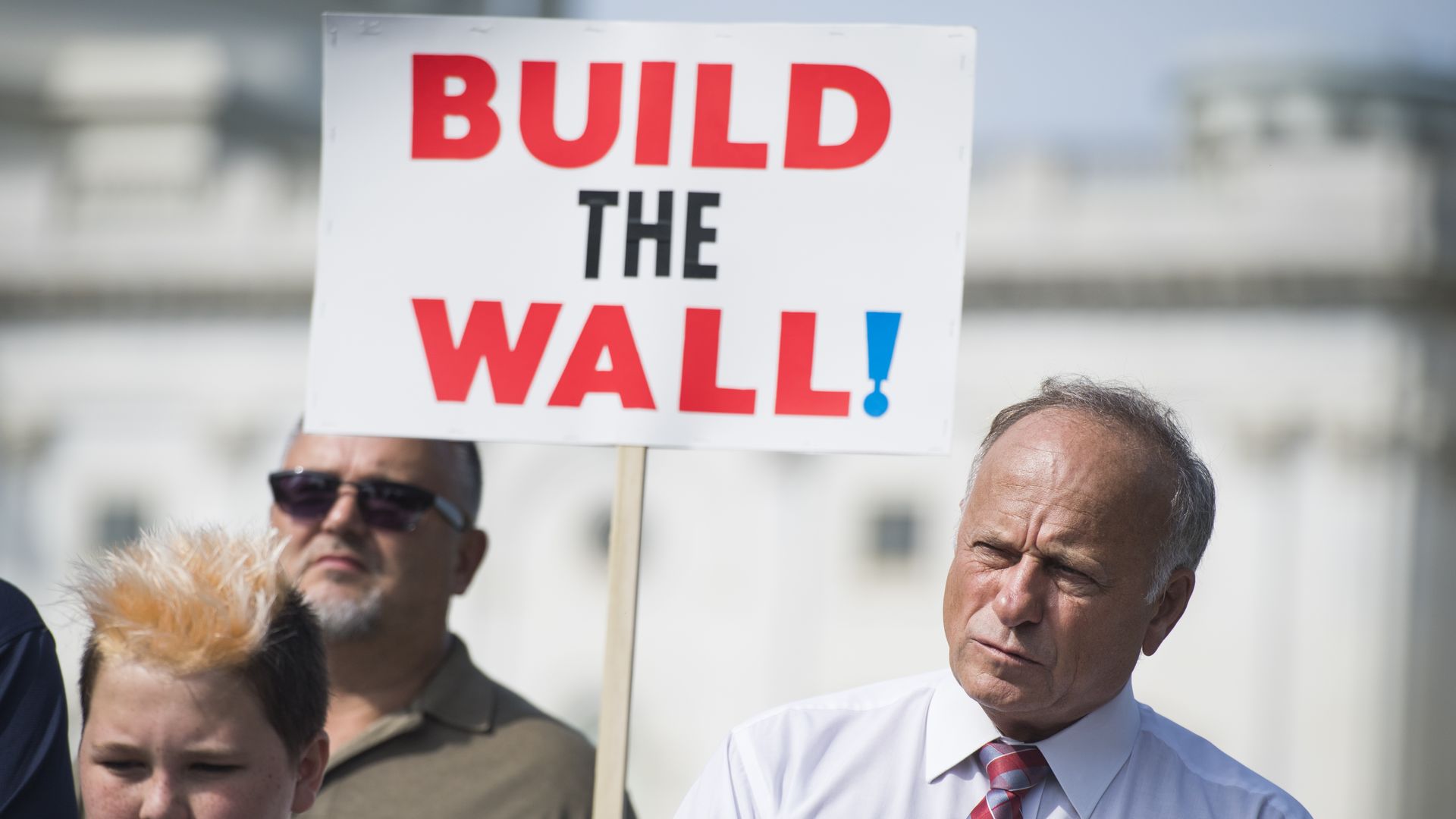 Steve King with a supporter holding a "Build the Wall" sign
