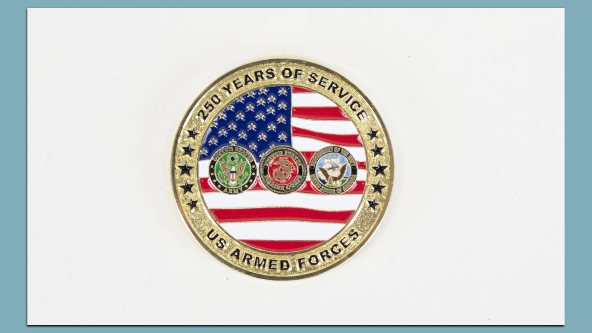 Gold commemorative coin with an American flag backdrop and three service emblems; outer ring reads "250 YEARS OF SERVICE" and "US ARMED FORCES" with stars along the rim.