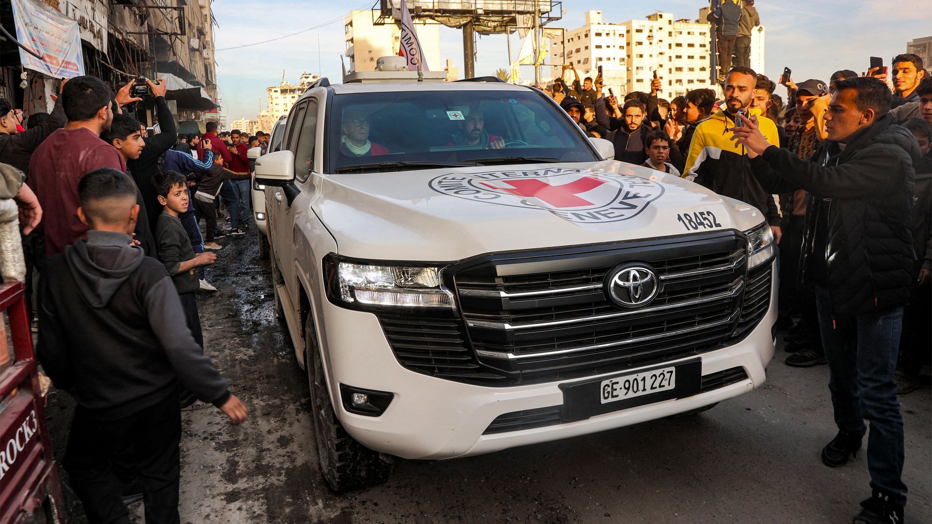 People gather around a vehicle of the International Committee of the Red Cross (ICRC) in Saraya Square in western Gaza City on January 19, 2025. 