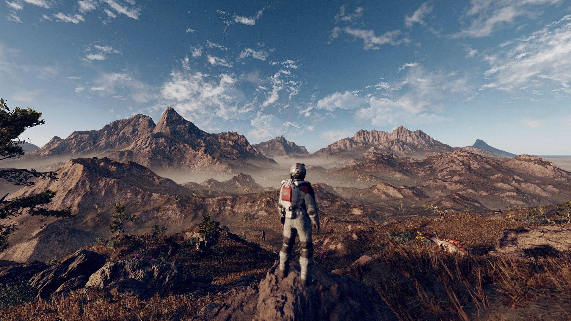 Video game screenshot of a person in a spacesuit looking out at a mountain vista