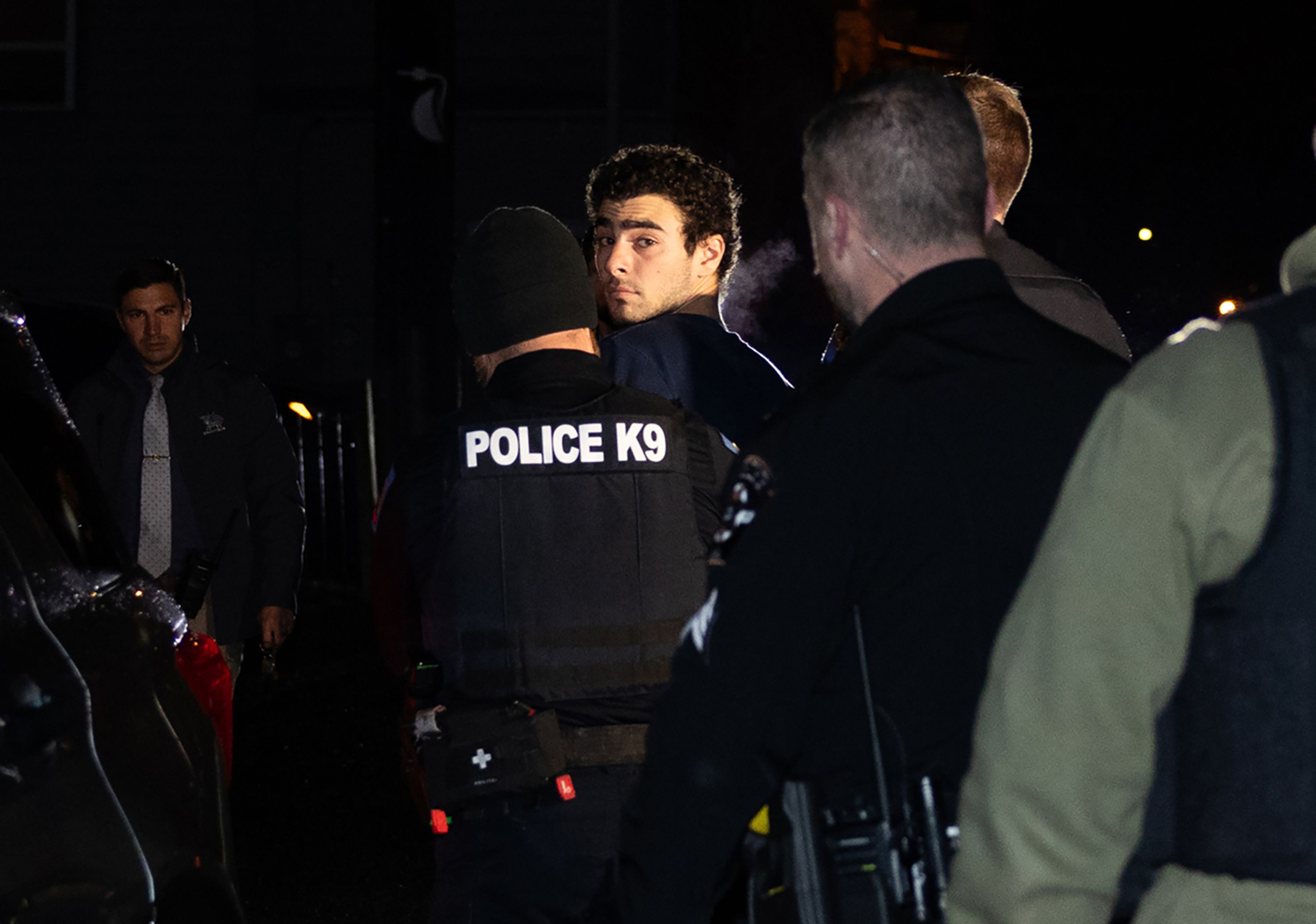 Luigi Mangione is escorted by police to his arraignment yesterday at the Blair County Courthouse in Hollidaysburg, Pa.,
