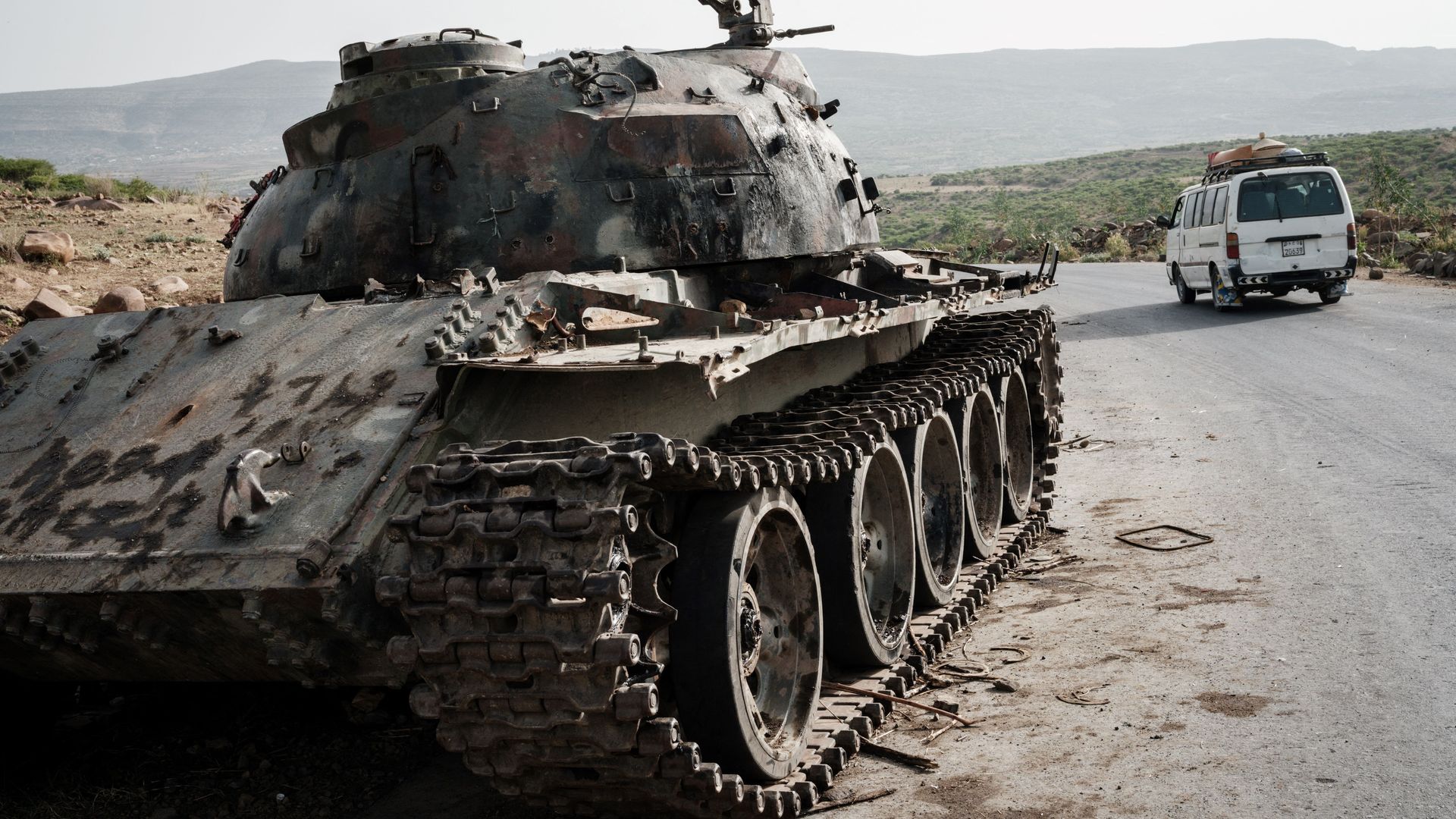 A local transport minibus passes a tank of alledged Eritrean army abandoned along the road in Dansa, southwest of Mekele in Tigray region, Ethiopia, on June 20, 2021.