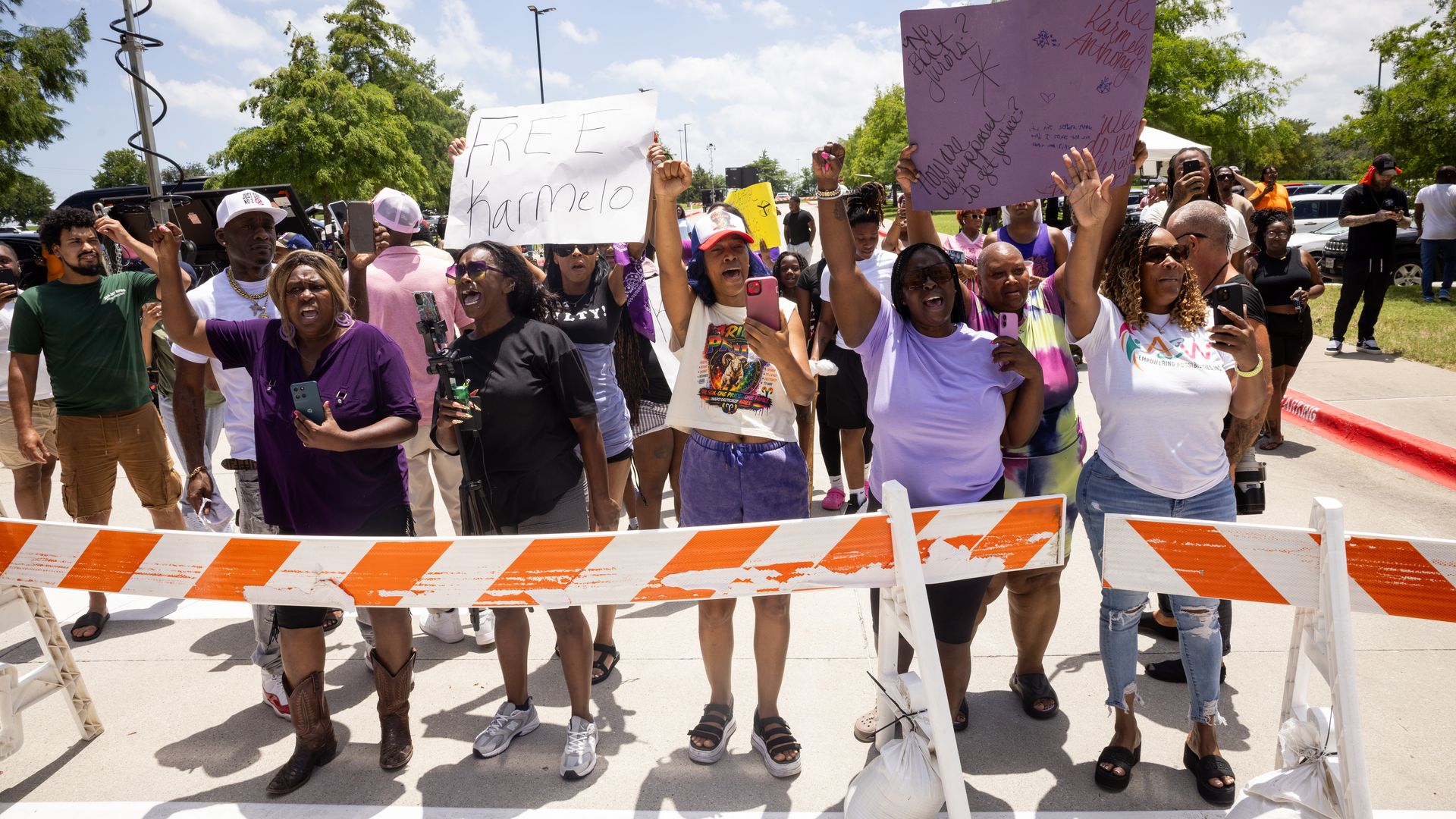 Supporters of Karmelo Anthony protest on June 9 outside the Collin County Courthouse in McKinney. One of them holds a sign that says, "Free Karmelo."
