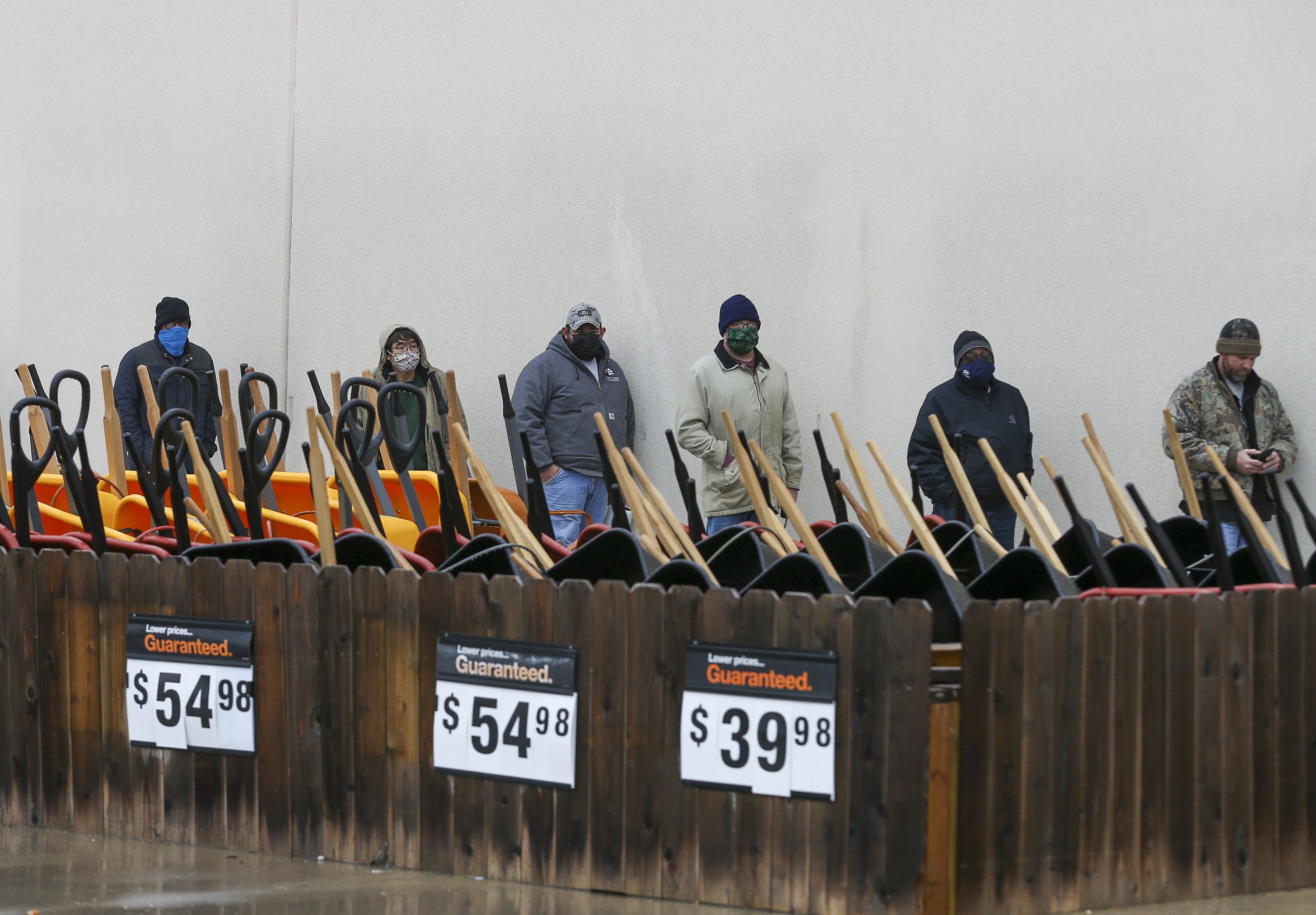 Customers wait outside at a Home Depot in Pearland, Texas to enter the store to buy supplies on February 17