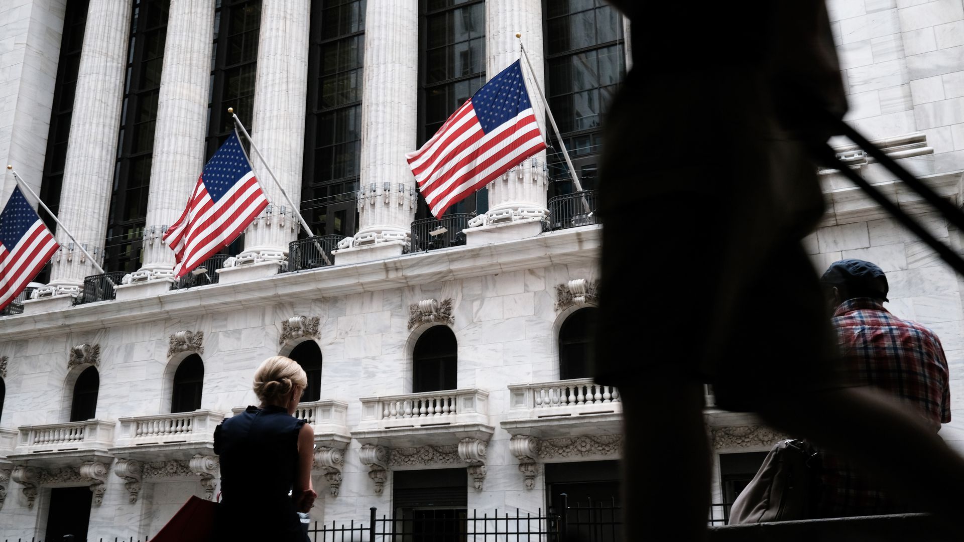 Photo of people walking outside the New York Stock Exchange building